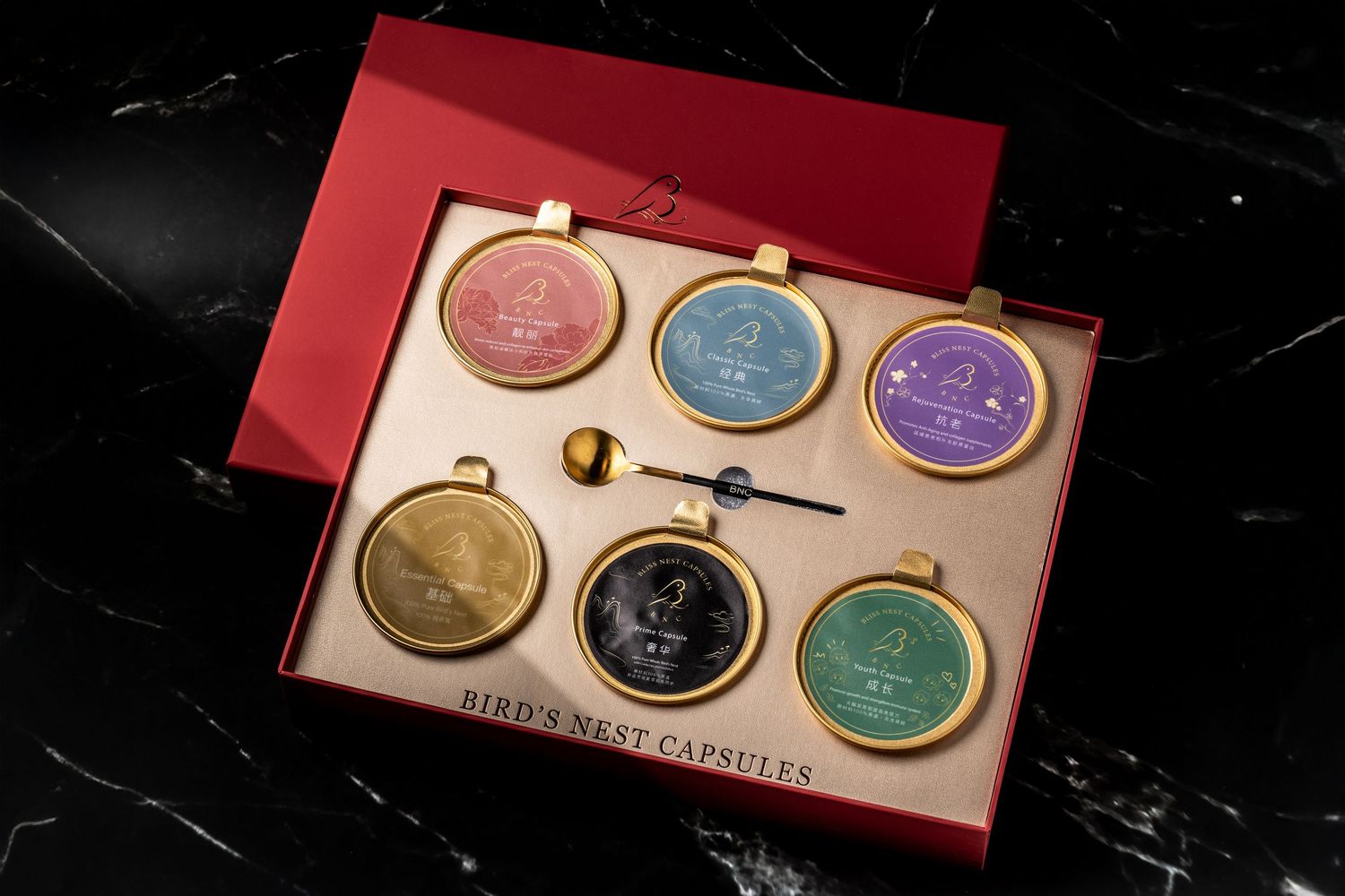 Luxury Bird's Nest Capsules gift set in red box with six colorful gold-rimmed tins and a small spoon.