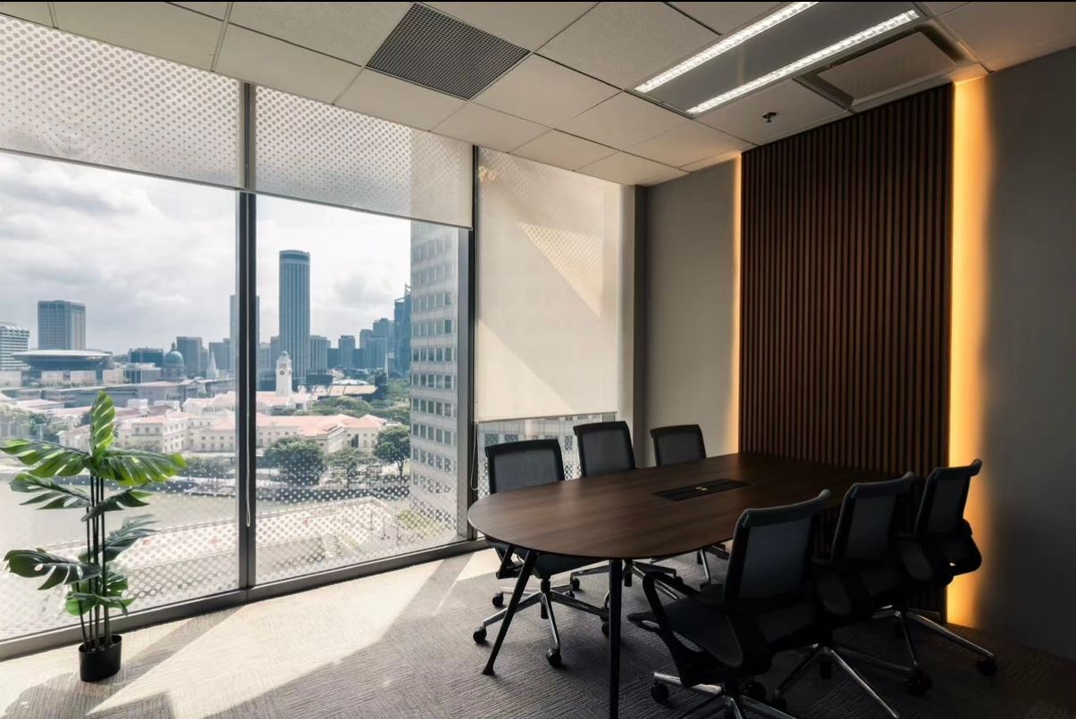 Modern conference room with floor-to-ceiling windows, city views, dark wood table, black chairs, and warm accent lighting on slatted wall.