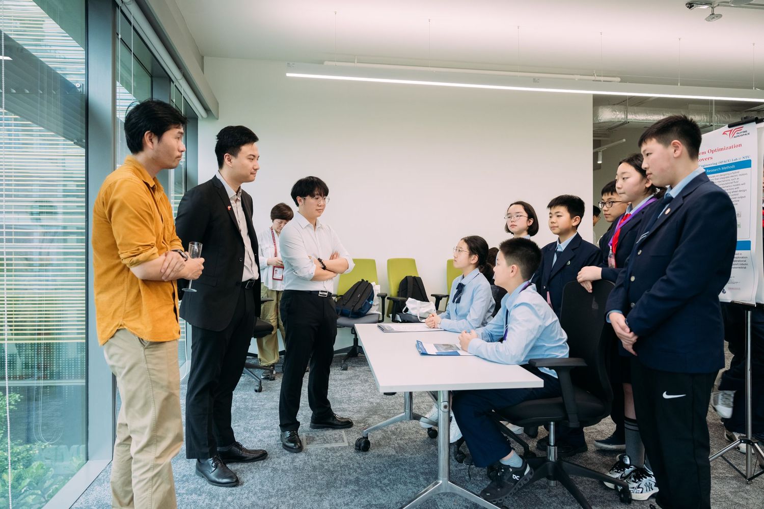 Business professionals in a modern office having a team meeting, with colleagues gathered around a conference table.