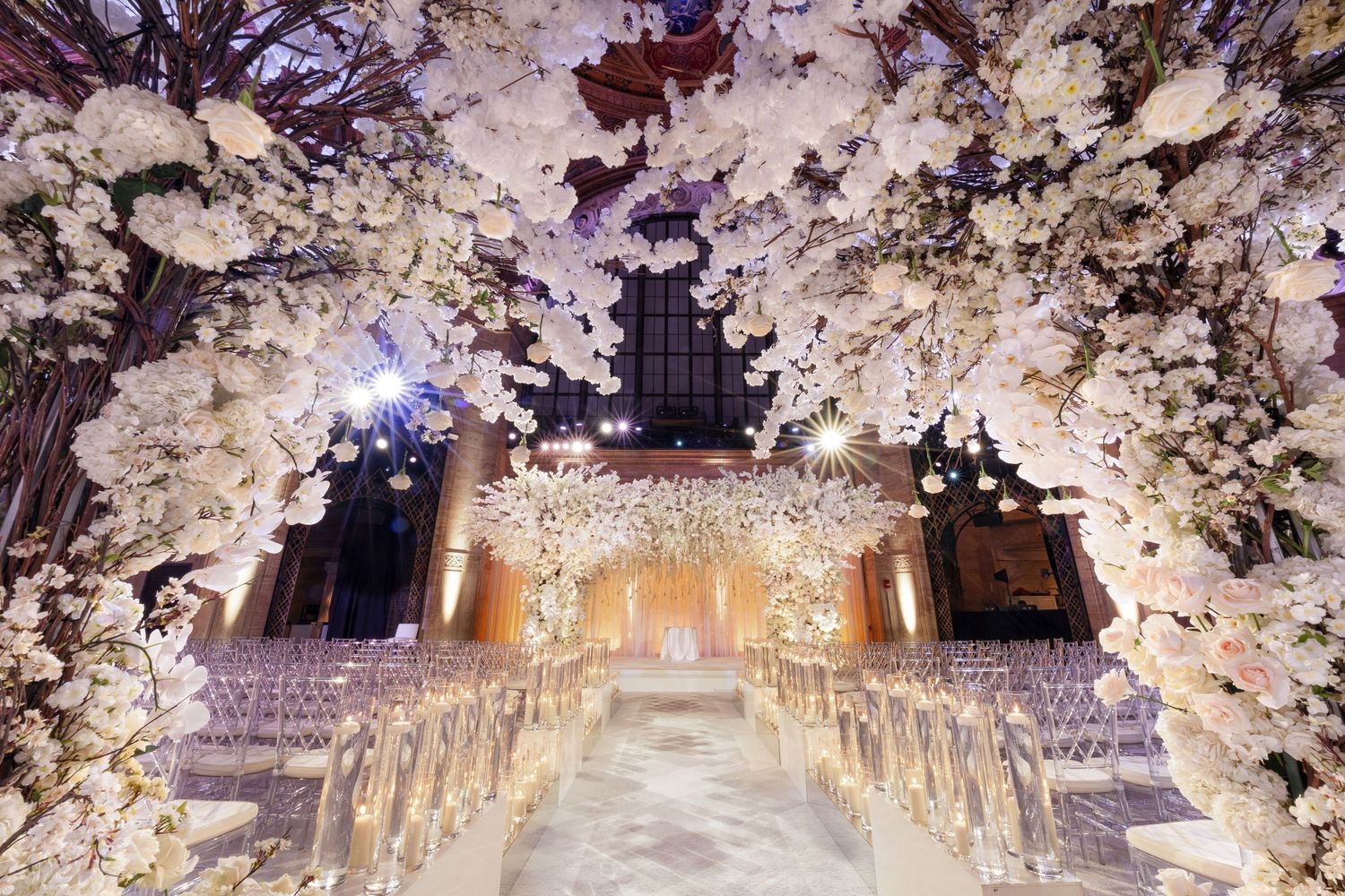 Luxury wedding aisle at Cipriani 42nd Street in New York—floral archway with cascading white blossoms leading to a golden altar.