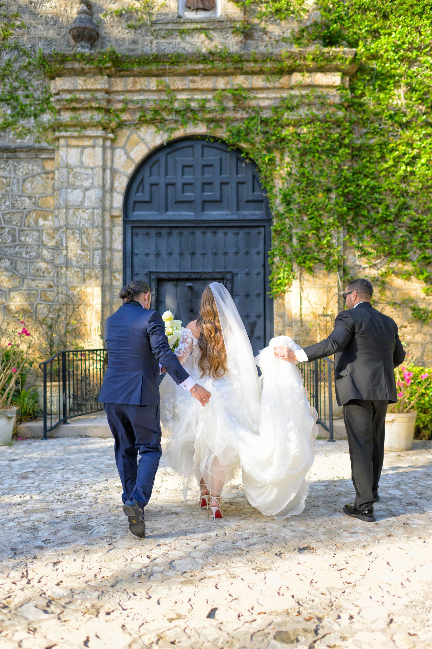 Bride is escorted to the church entrance before her walk down the aisle.