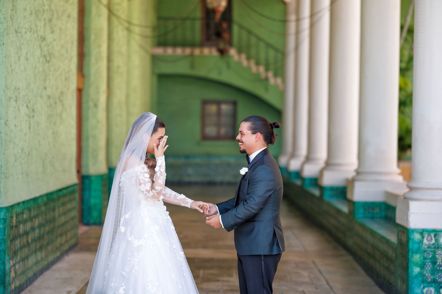 Joyful first look — the bride and groom smile as they see each other for the first time.