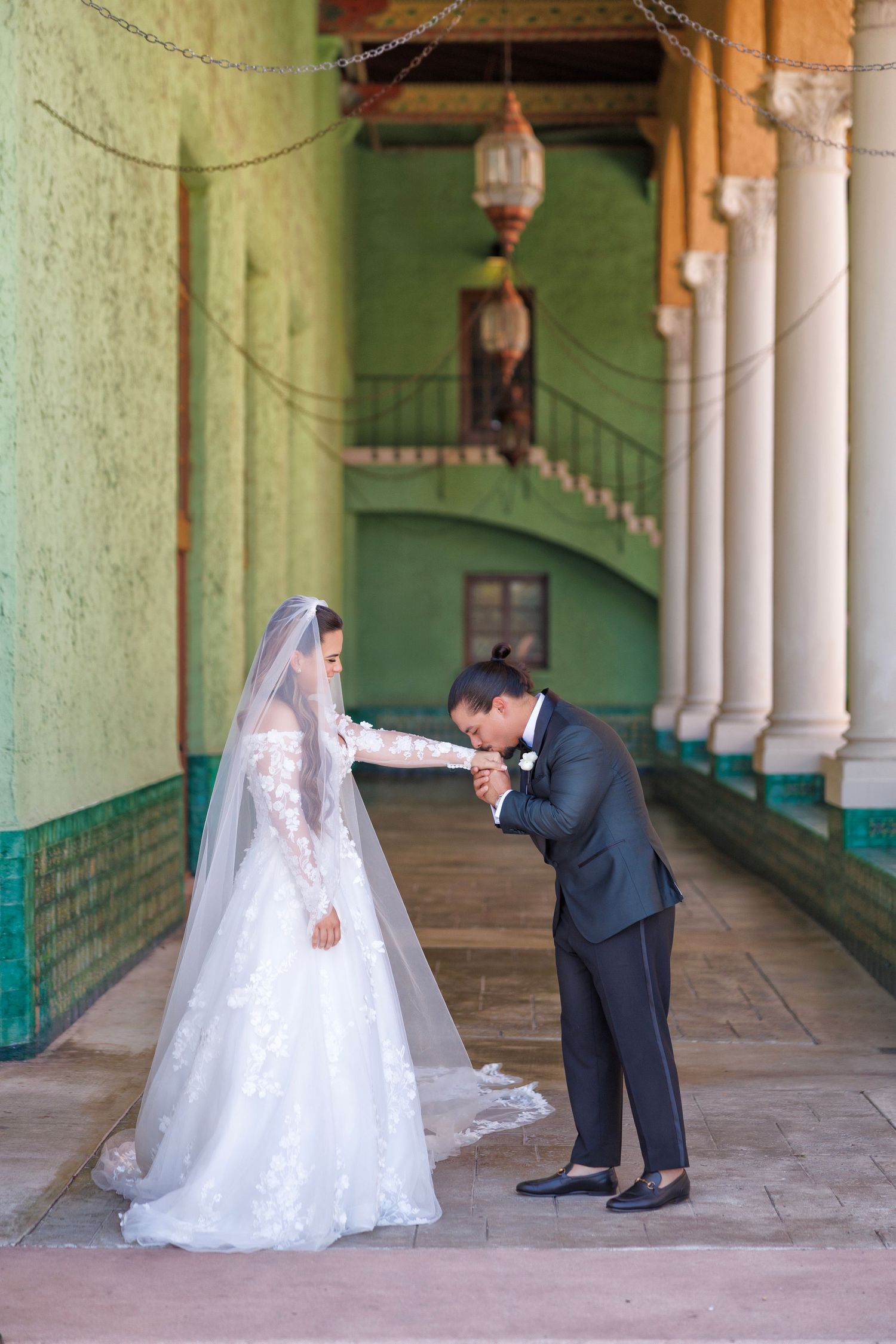 Bride and groom embrace against the pastel-hued architecture.