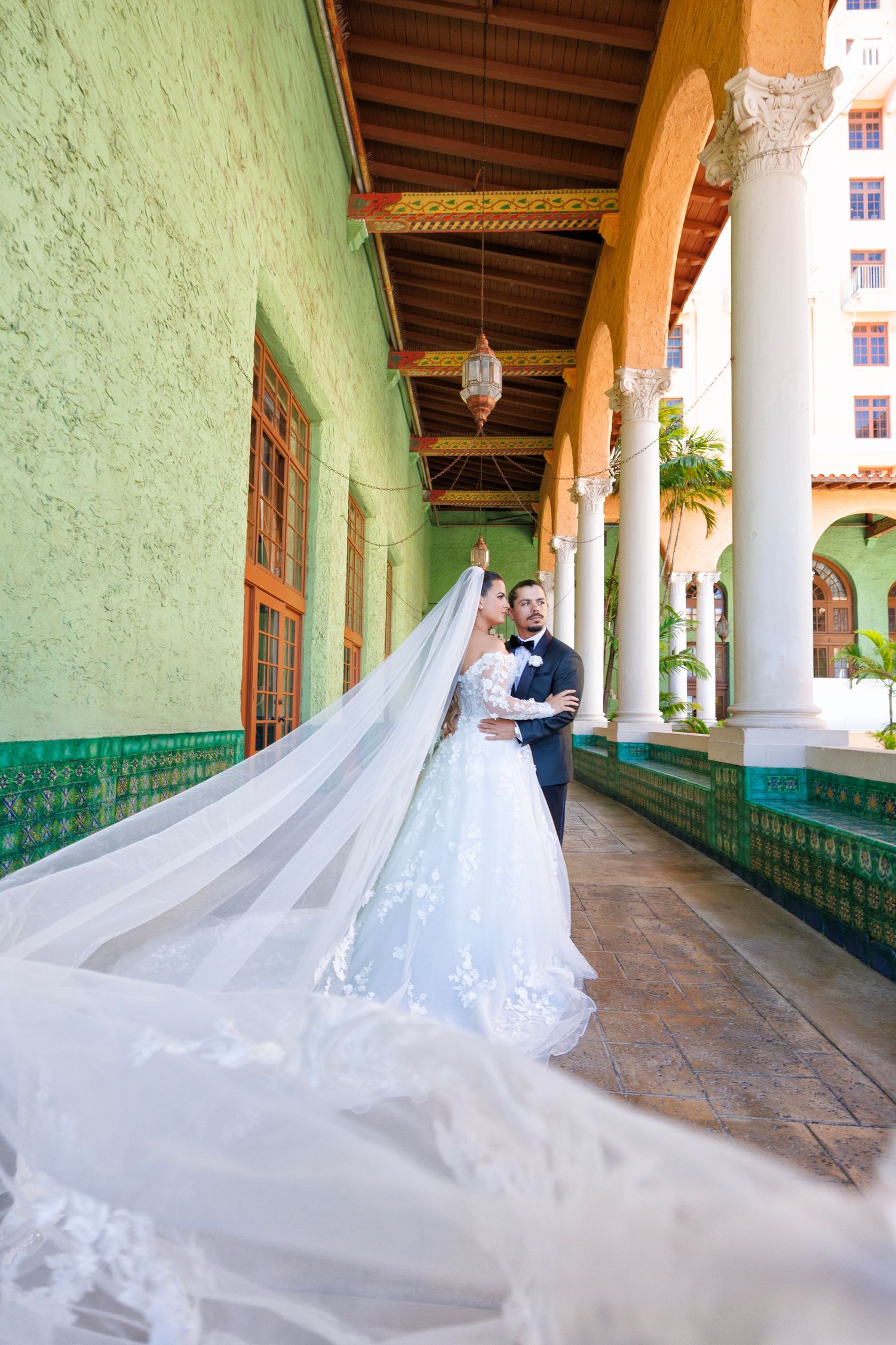 A striking bridal portrait with a dramatic veil cascading down the hallway, creating a sense of grandeur and elegance.