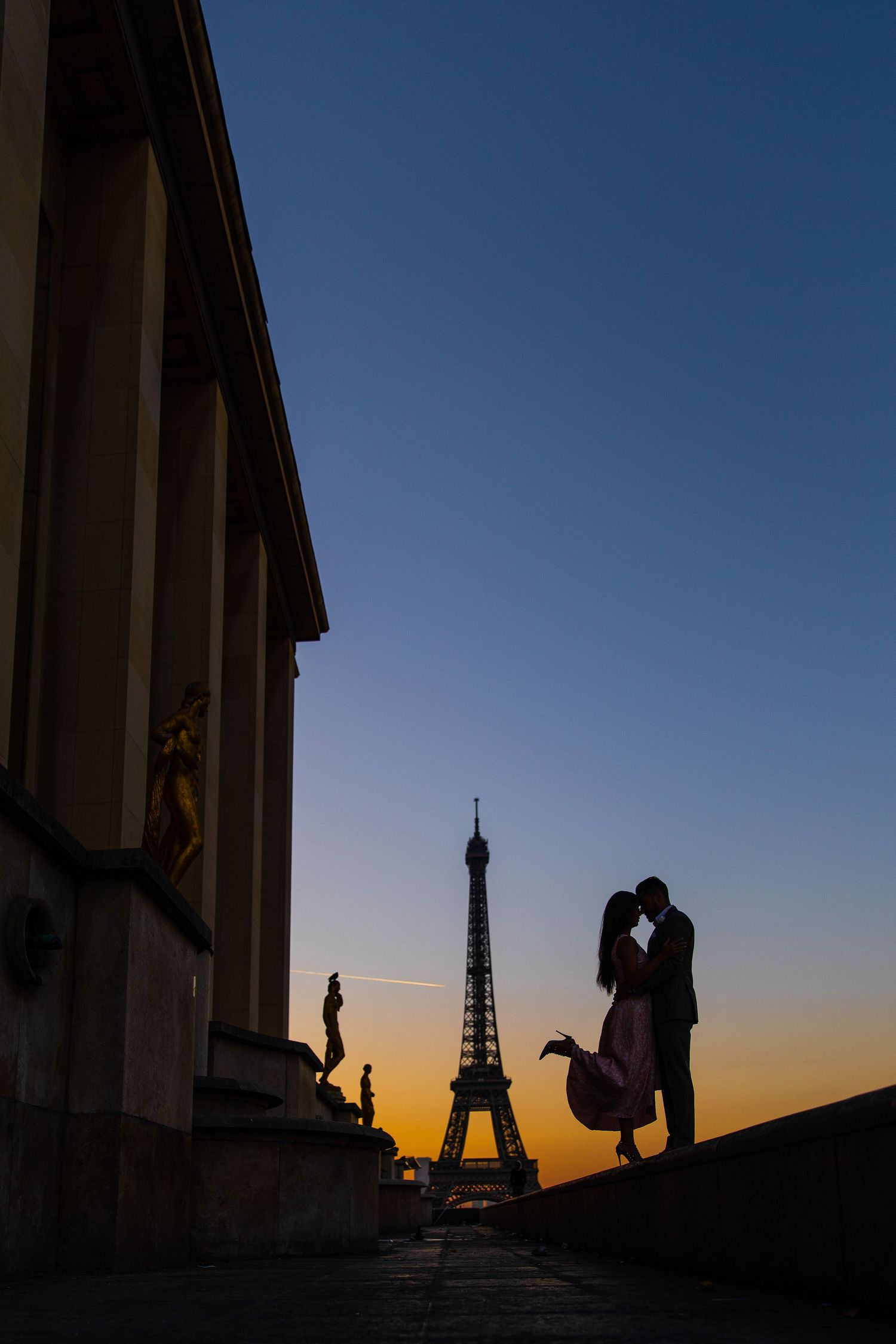 Silhouette of a bride and groom walking at sunset—artistic wedding photo with dramatic golden light.