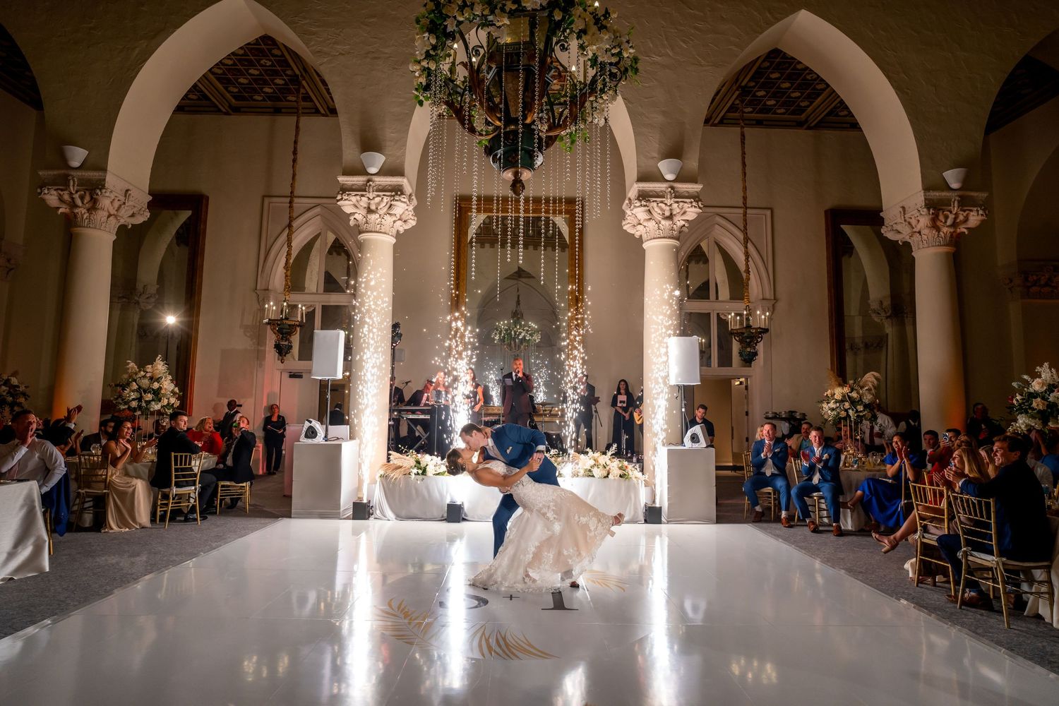 Bride and groom sharing their first dance in a grand ballroom—luxury wedding reception with elegant lighting.