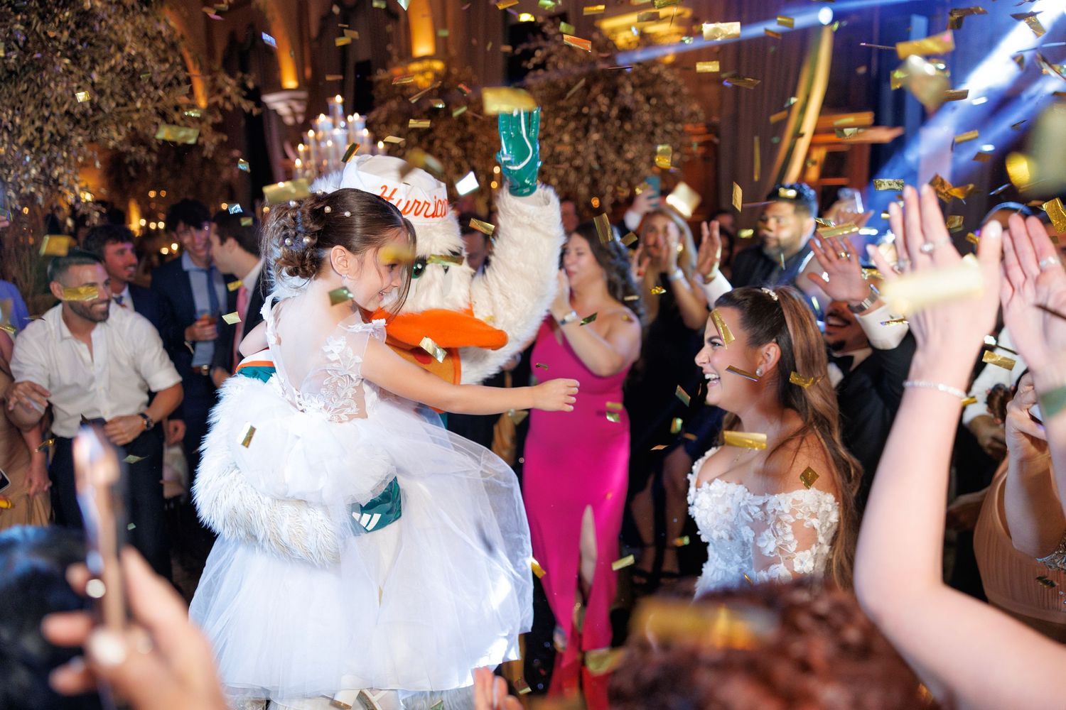 The bride is lifted joyfully into the air during the hora loca, while guests cheer and dance all around her.