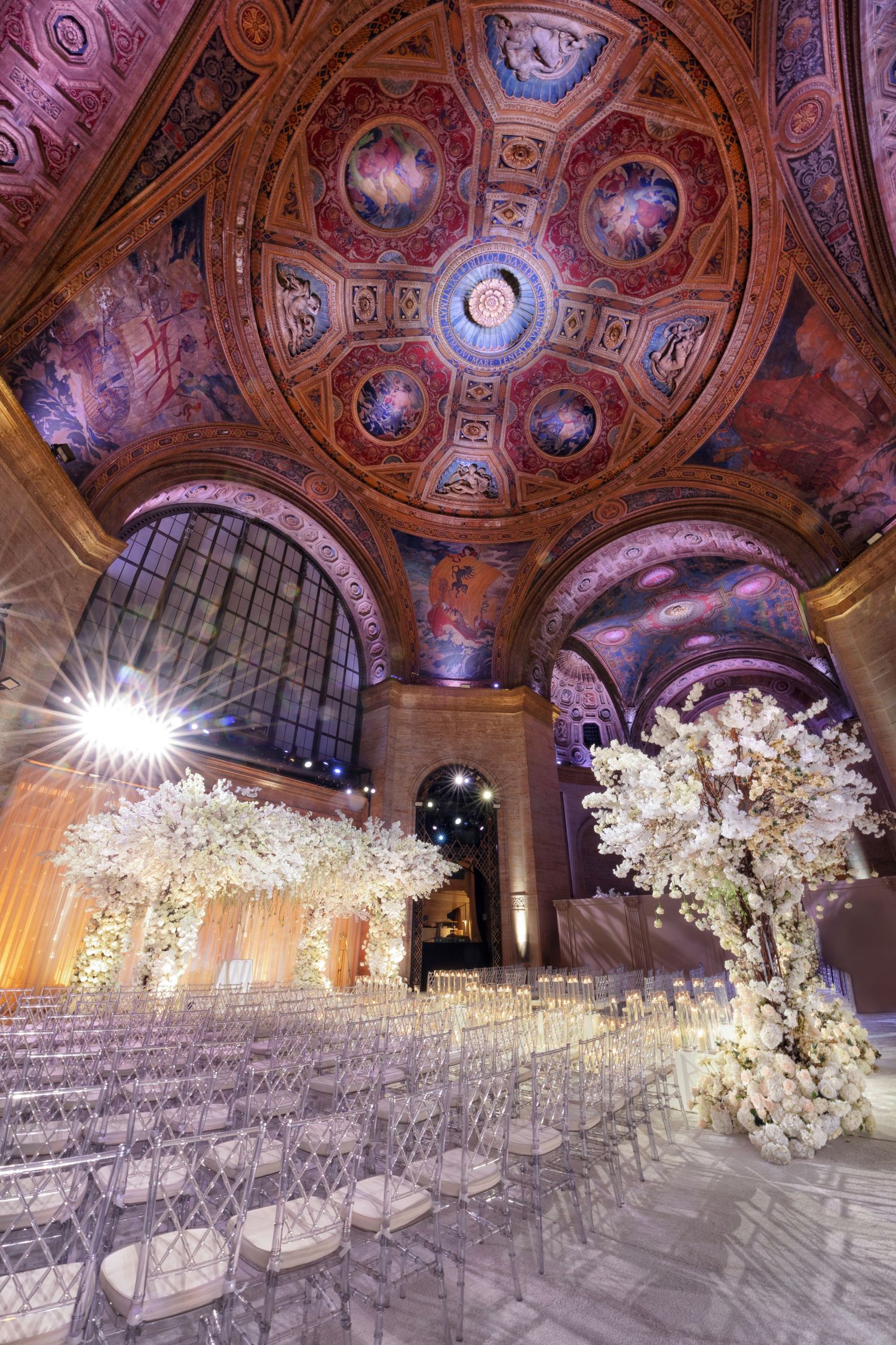 Cipriani 42nd Street wedding reception in New York—ornate vaulted ceiling with cascading florals and golden light.