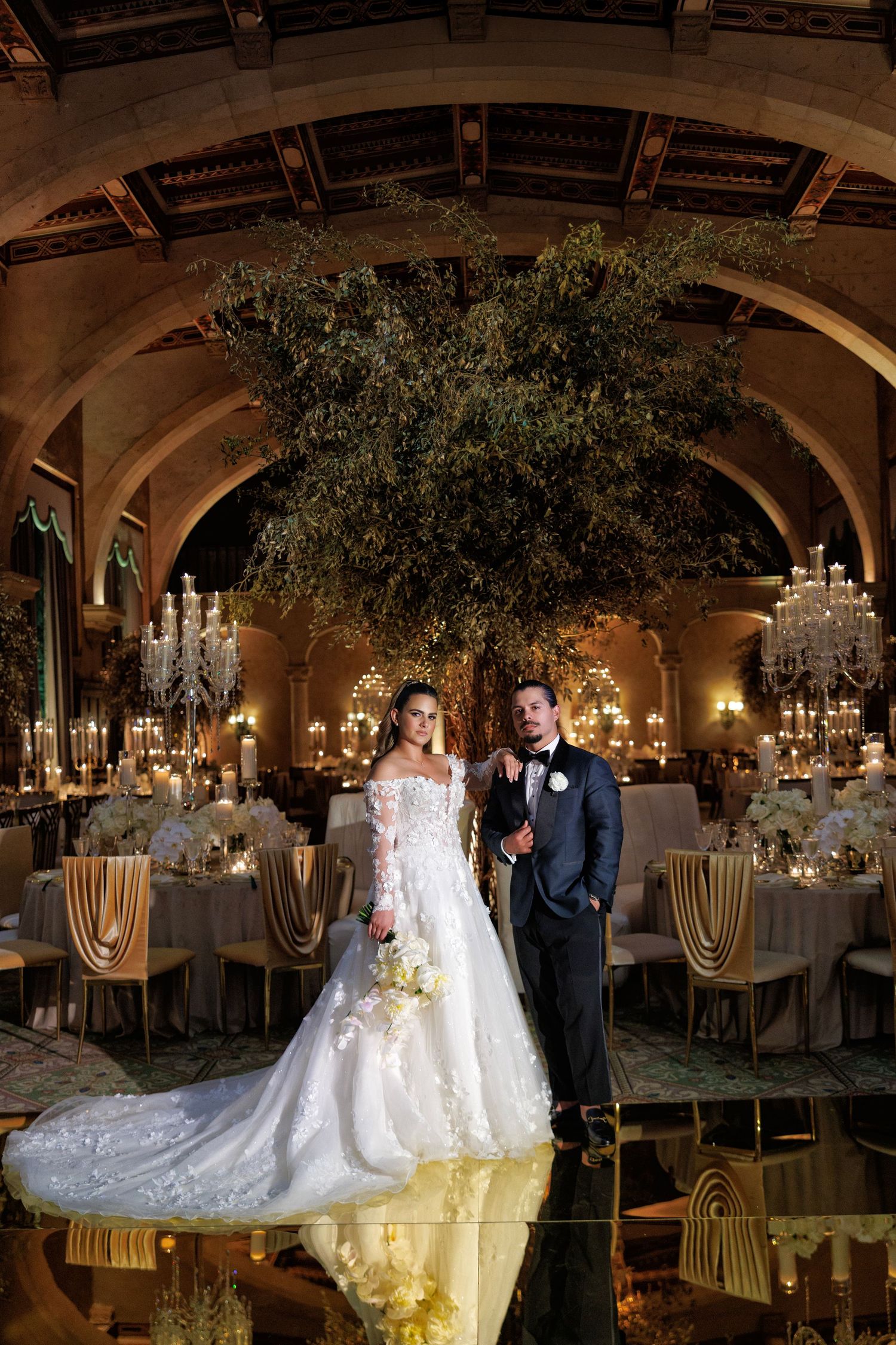 The couple shares a first dance in a golden, candlelit reception.