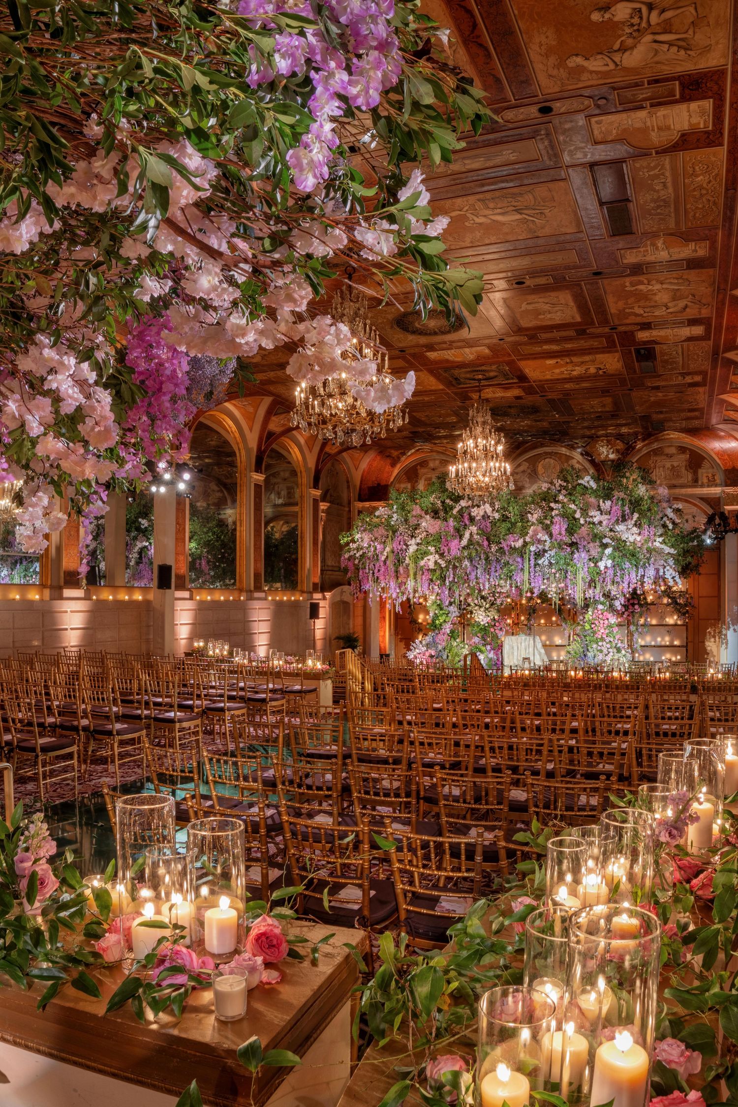 Luxury wedding ceremony at The Plaza, New York—cascading greenery, hanging florals, and an intimate candlelit atmosphere.
