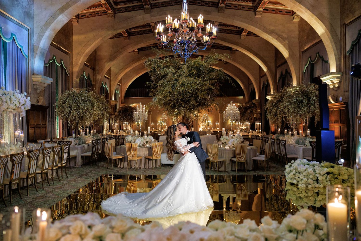 Bride twirls on the dance floor as chandeliers glow above.