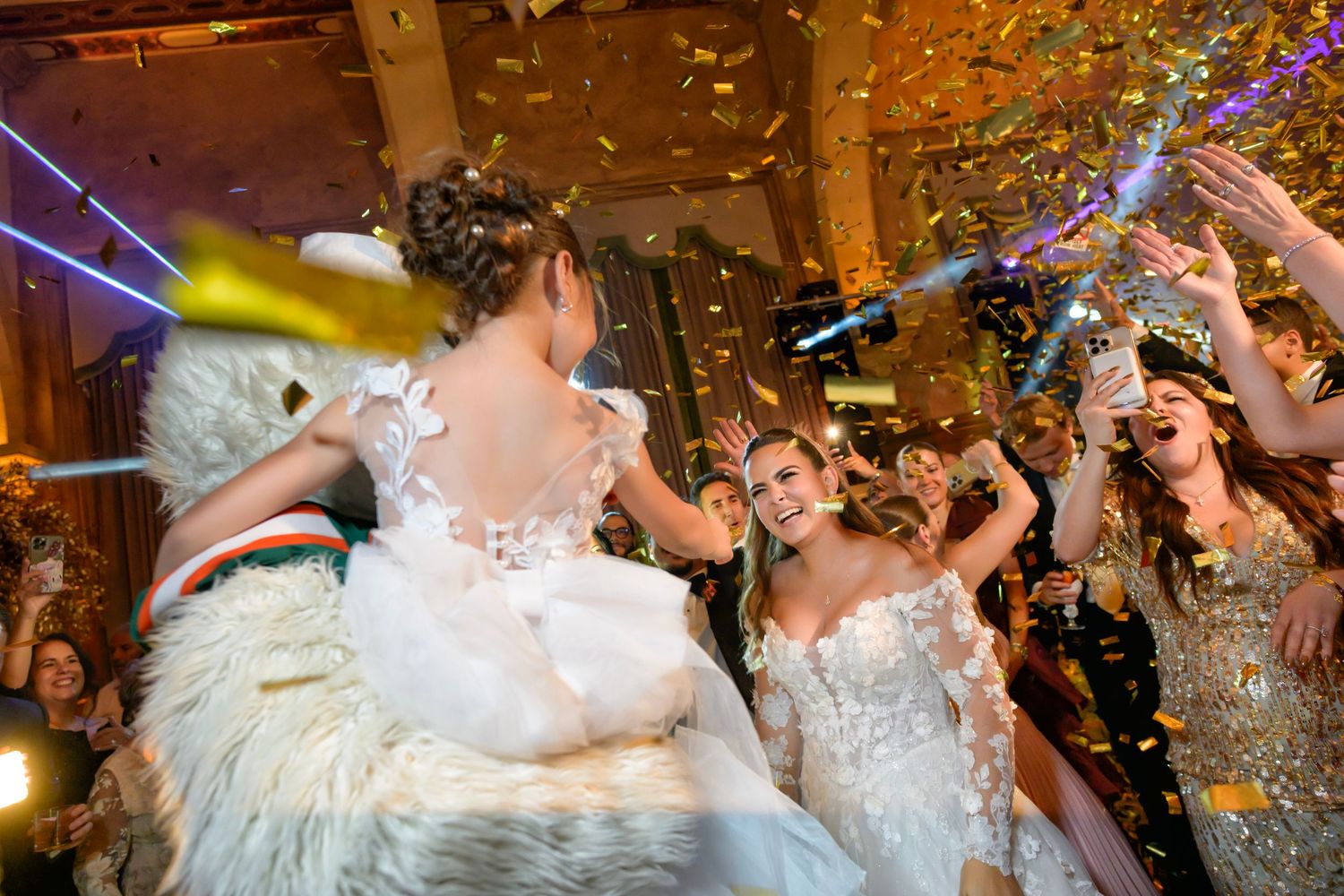 The bride celebrates with guests under a shower of confetti and sparkling lights.