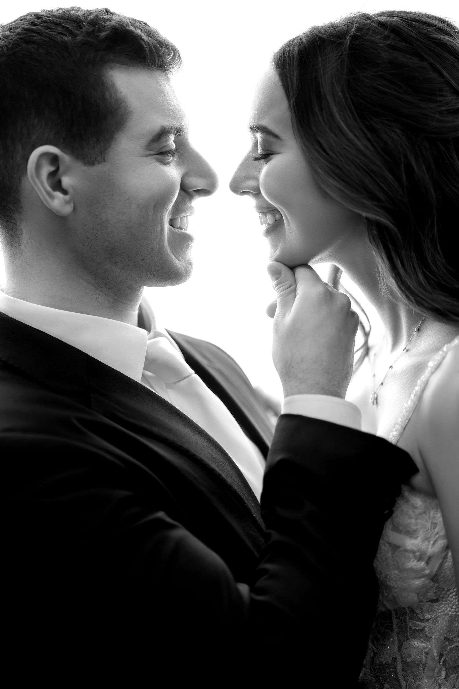 Black and white wedding portrait—bride and groom sharing an intimate moment with refined, editorial style.