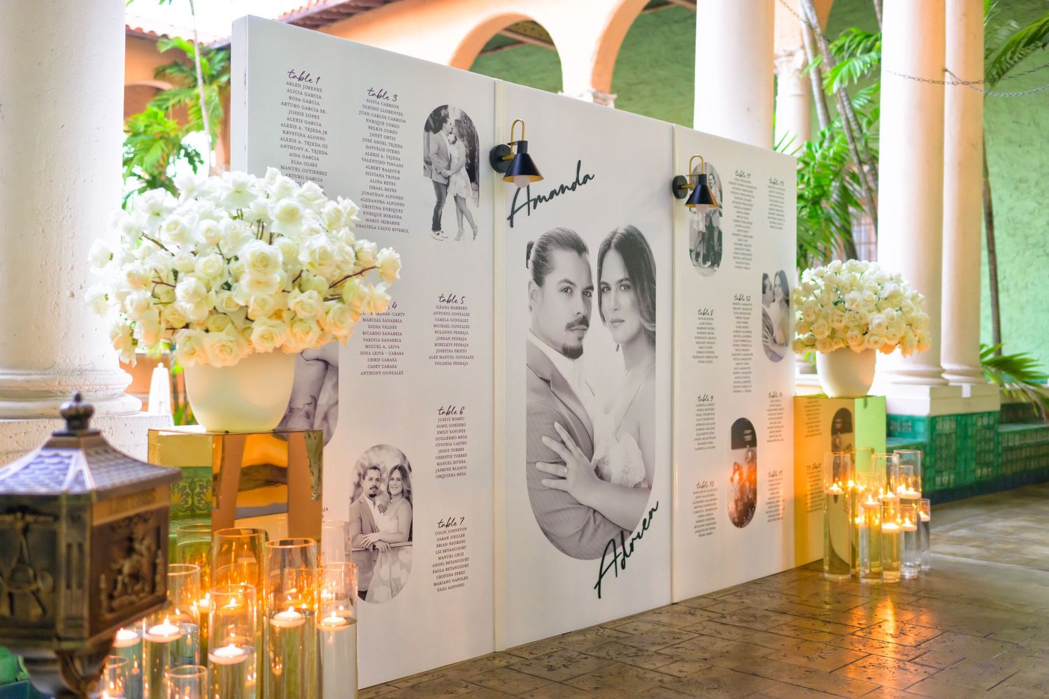 A chic black-and-white photo wall surrounded by lush florals welcomes guests in style.