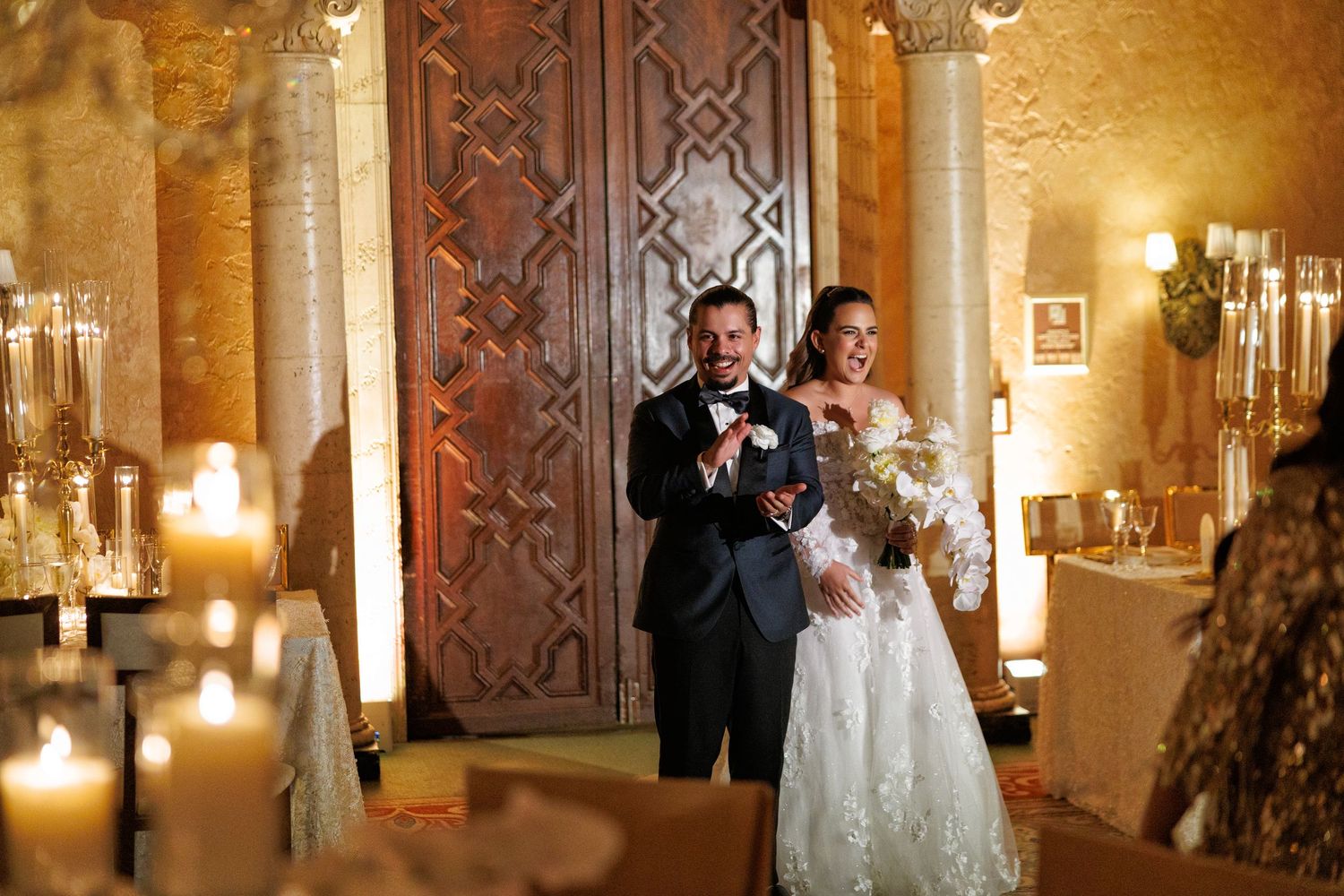 Walking hand in hand into forever, framed by golden candlelight.
