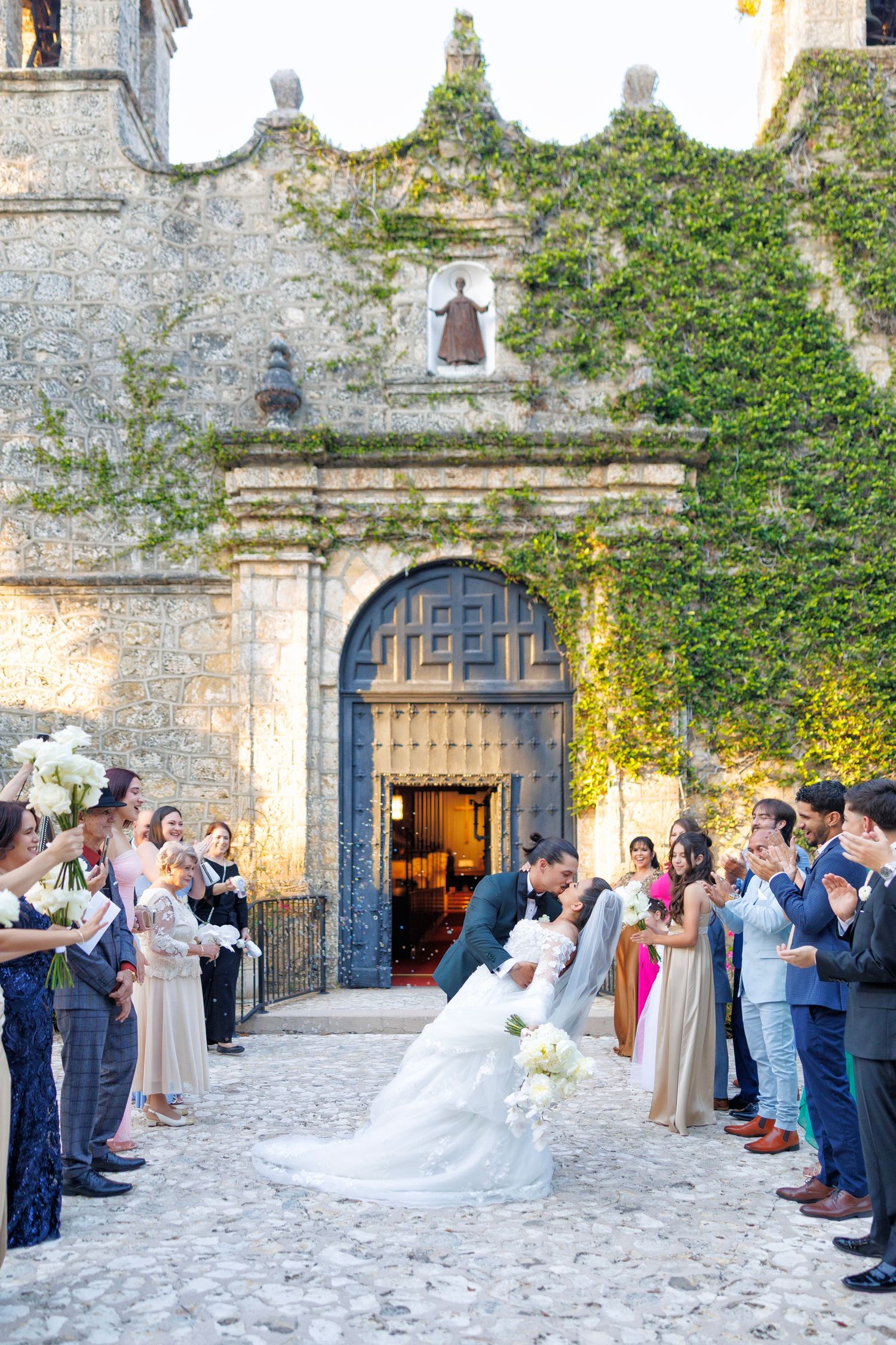 Guests gather outside the ivy-covered stone chapel, awaiting the bride’s grand entrance.