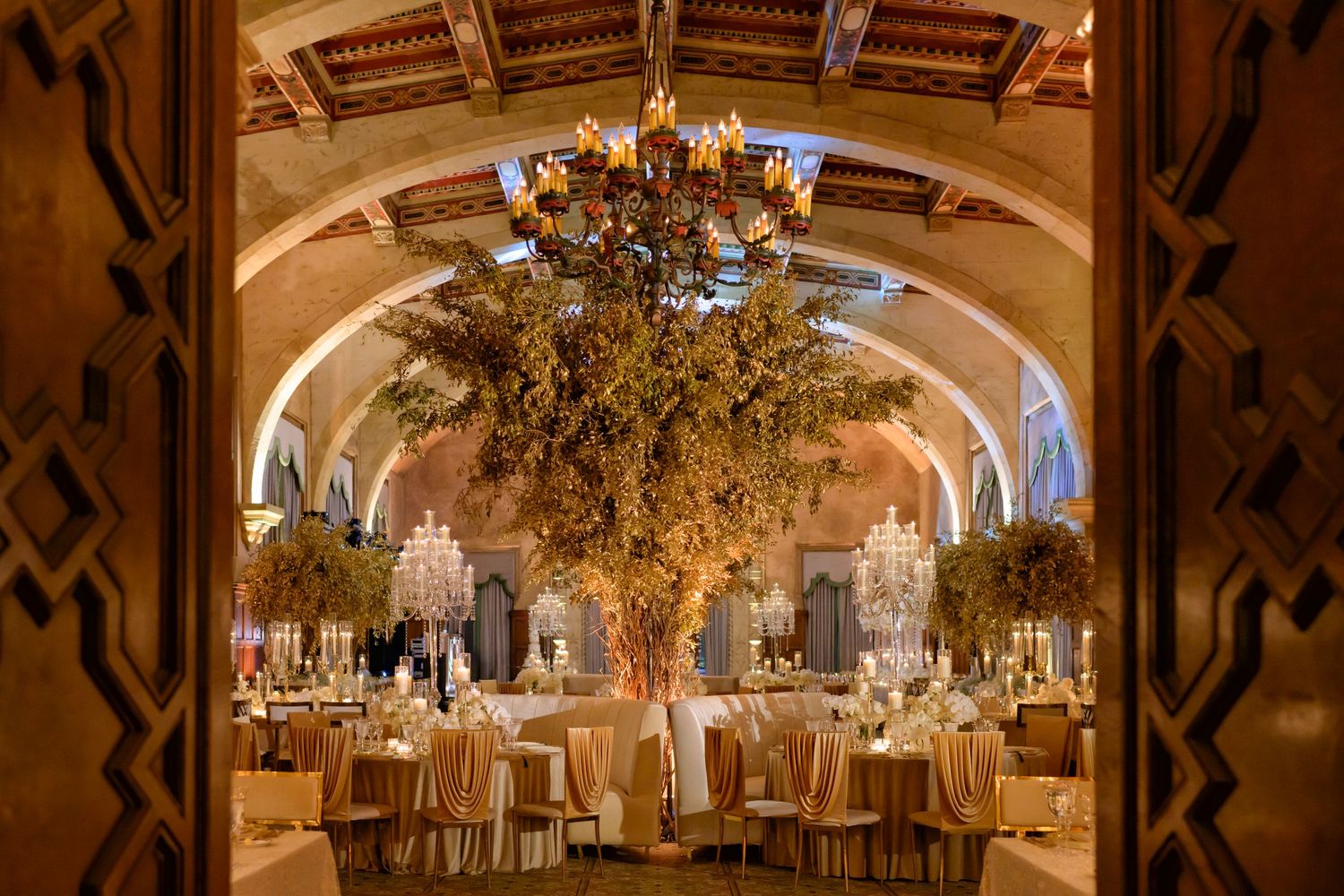 Golden reception hall glowing with candlelight and lush florals at The Biltmore.