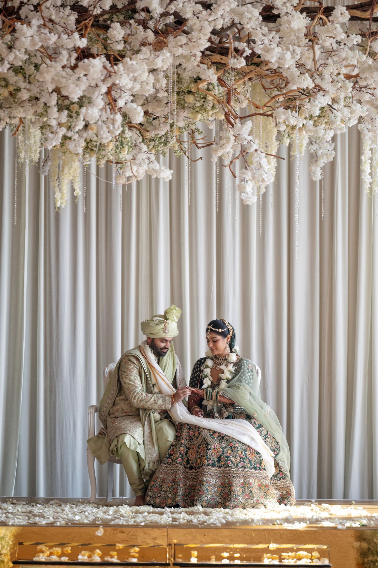 Traditional Indian wedding ceremony in Mexico City—bride and groom seated under a floral mandap with elegant decor.