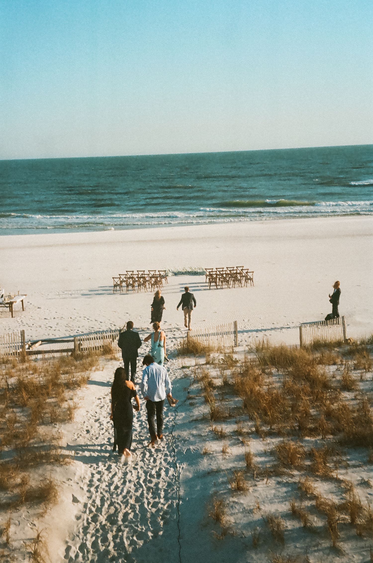 Guests walking to a beachfront ceremony for an intimate micro wedding