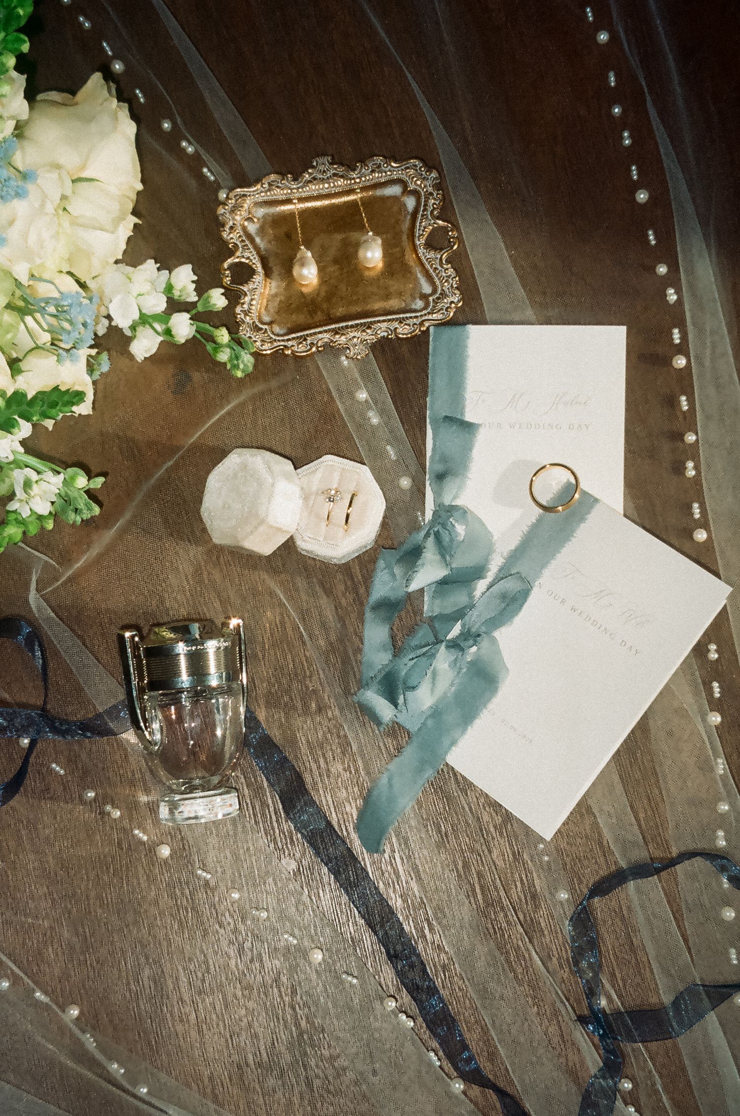 Wedding invitation suite featuring rings, stationery, and personal details