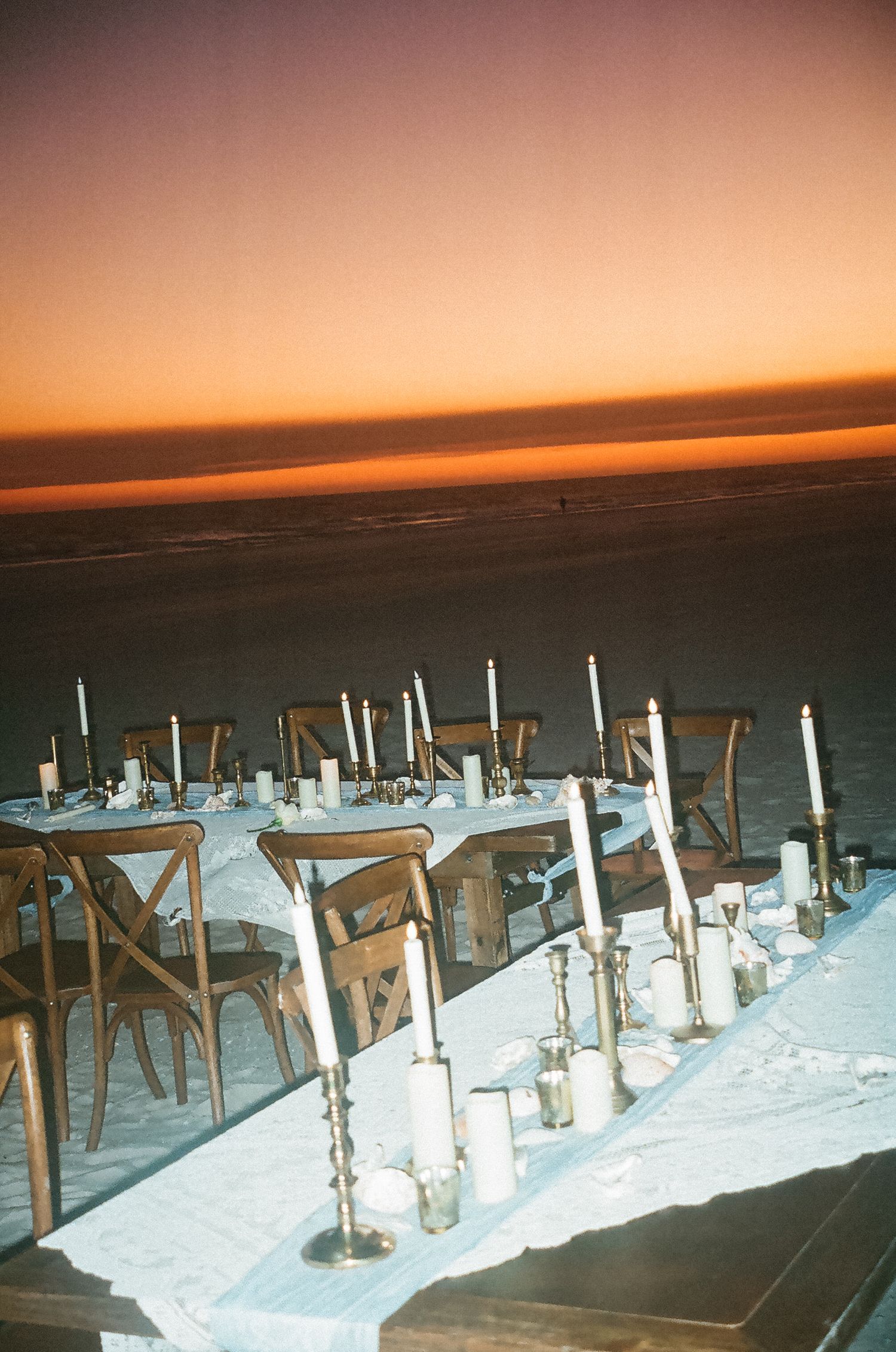 Wedding dinner table on the beach during sunset with flash photography