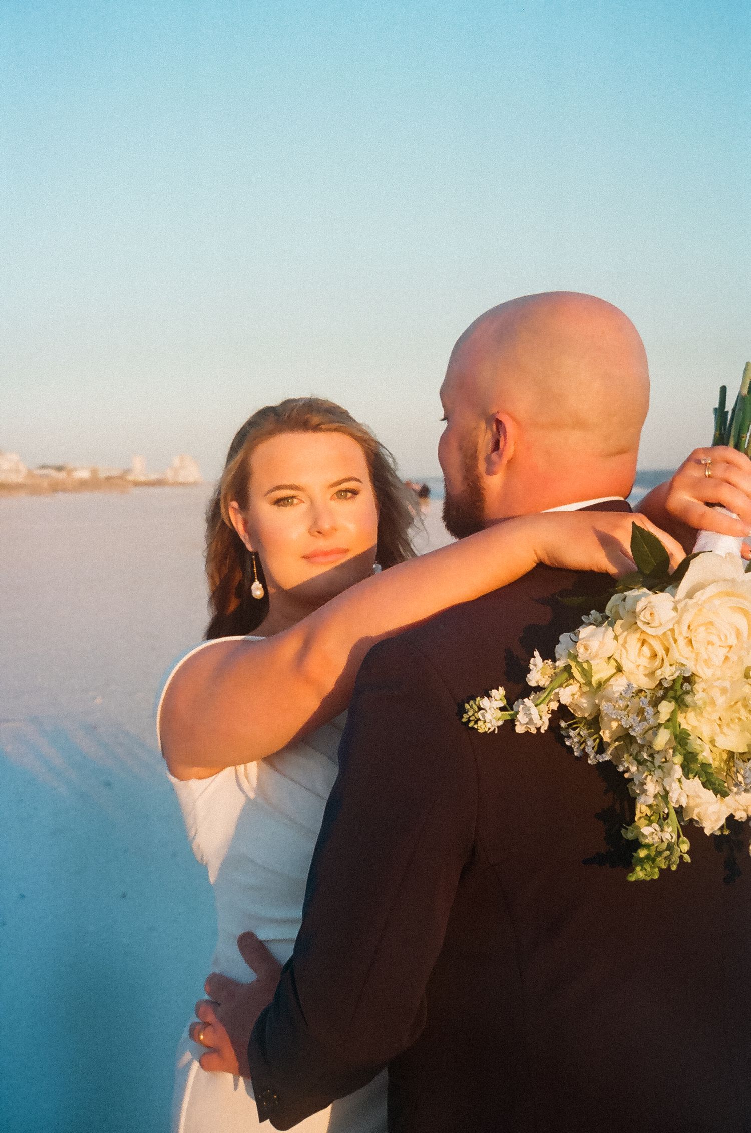 Golden hour wedding portraits of bride and groom on the Alabama coast