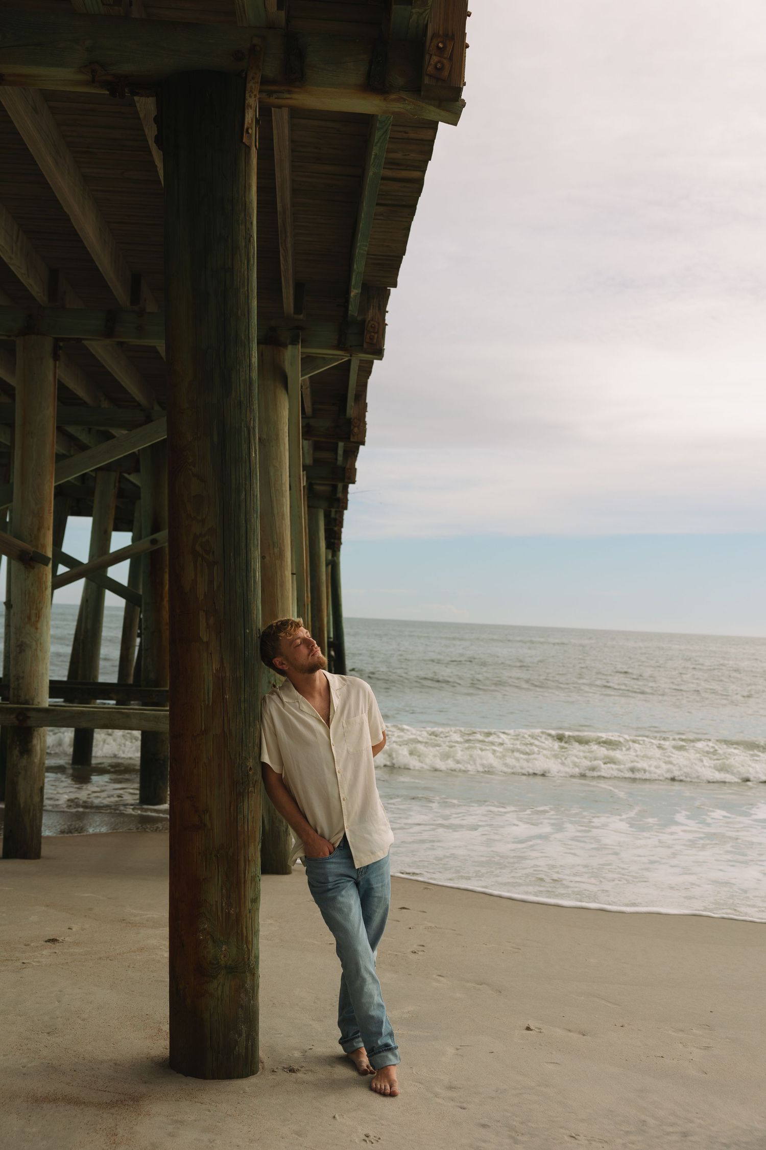 Portrait of a man standing on a pier at sunset