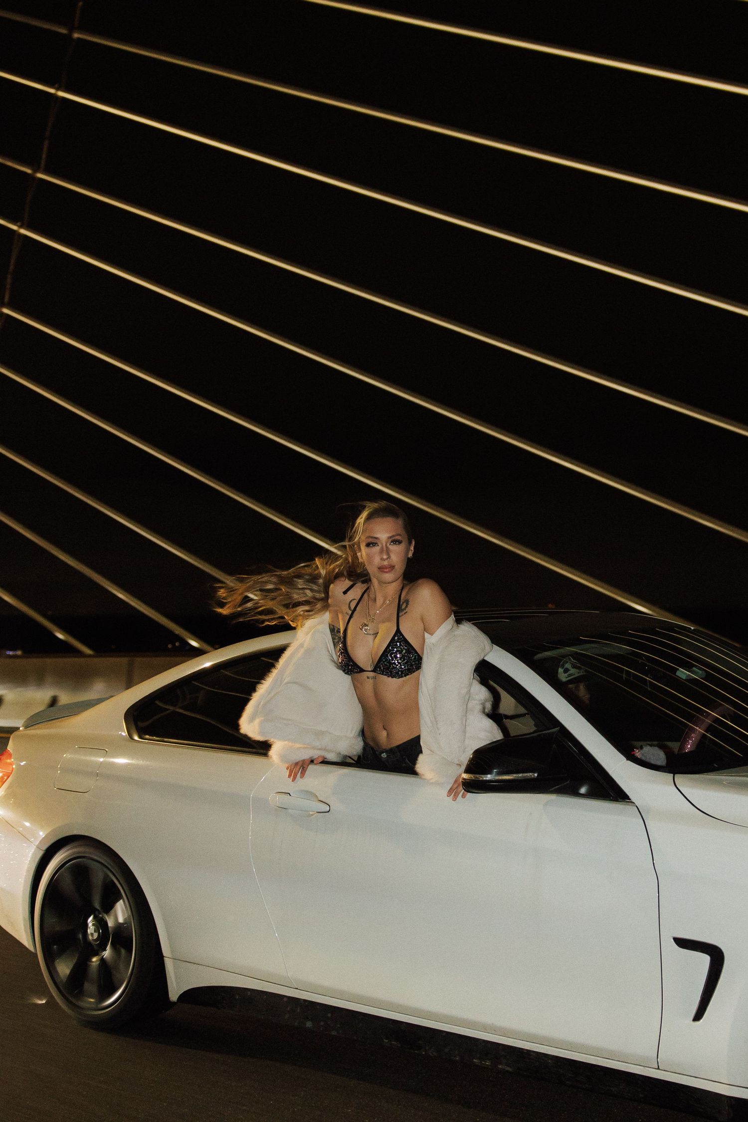 Creative portrait session featuring a woman hanging out of a car window