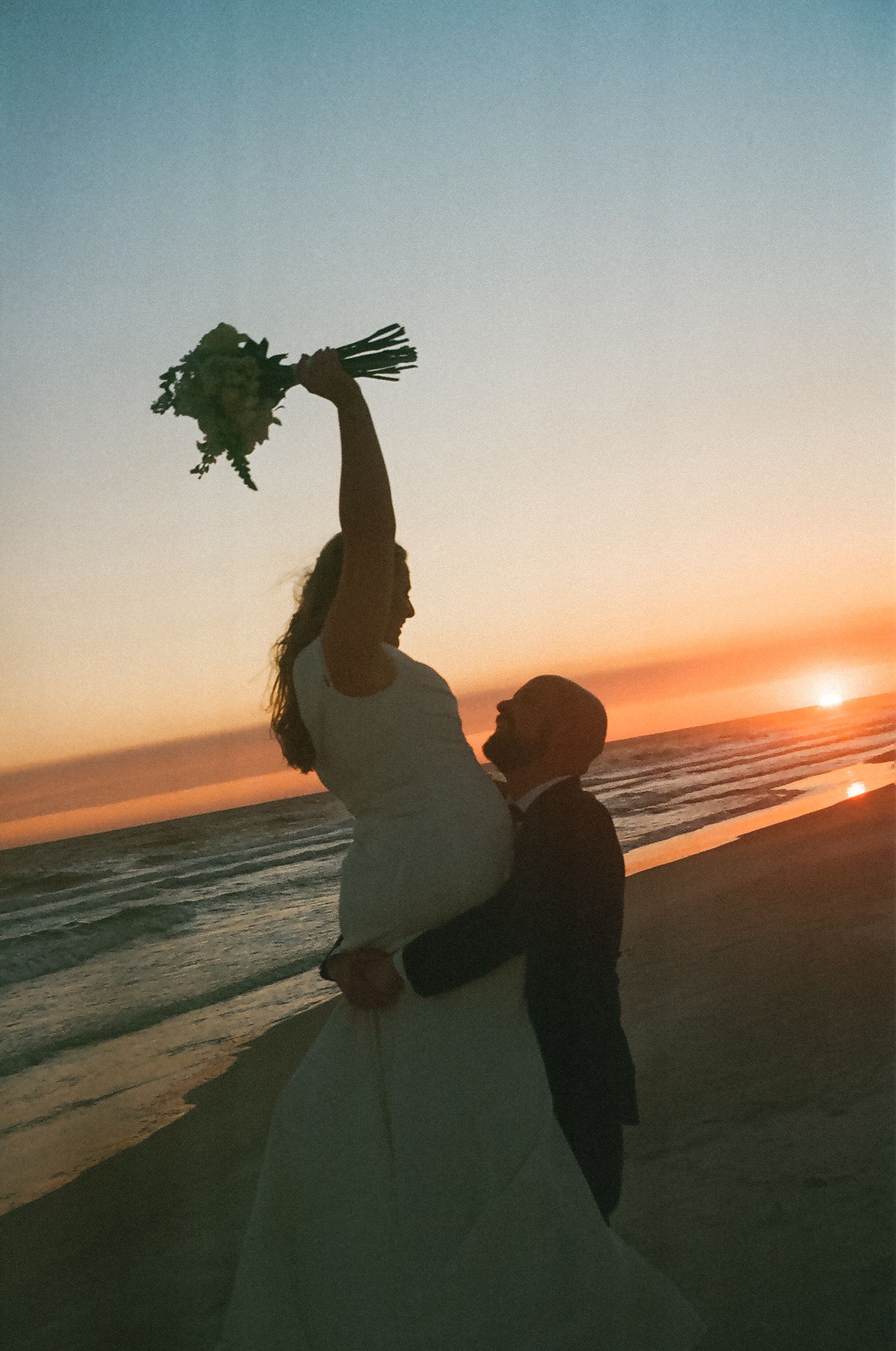 Bride and groom portraits on the beach at sunset after their wedding