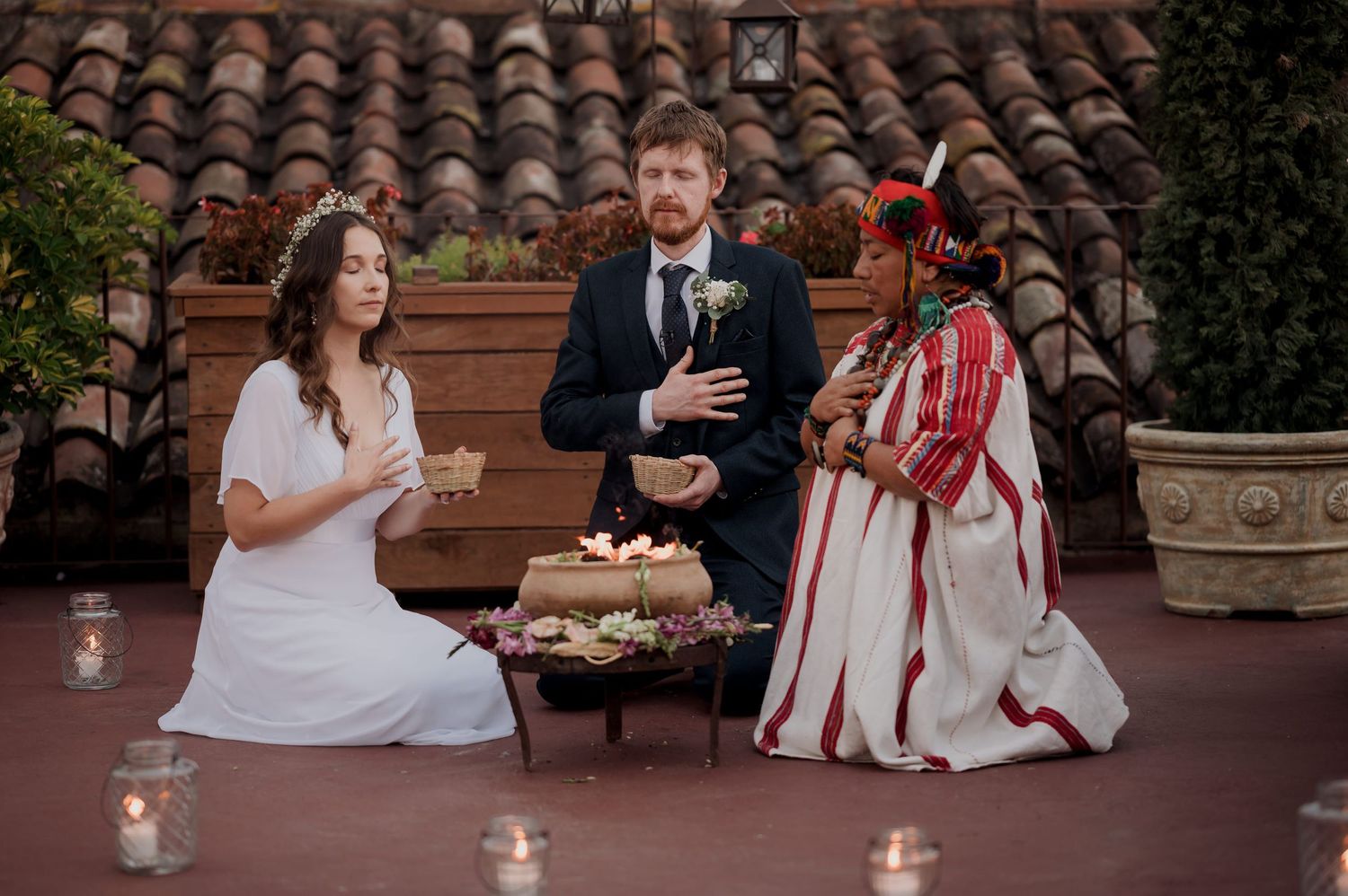 Three people participating in a traditional wedding ceremony outdoors.