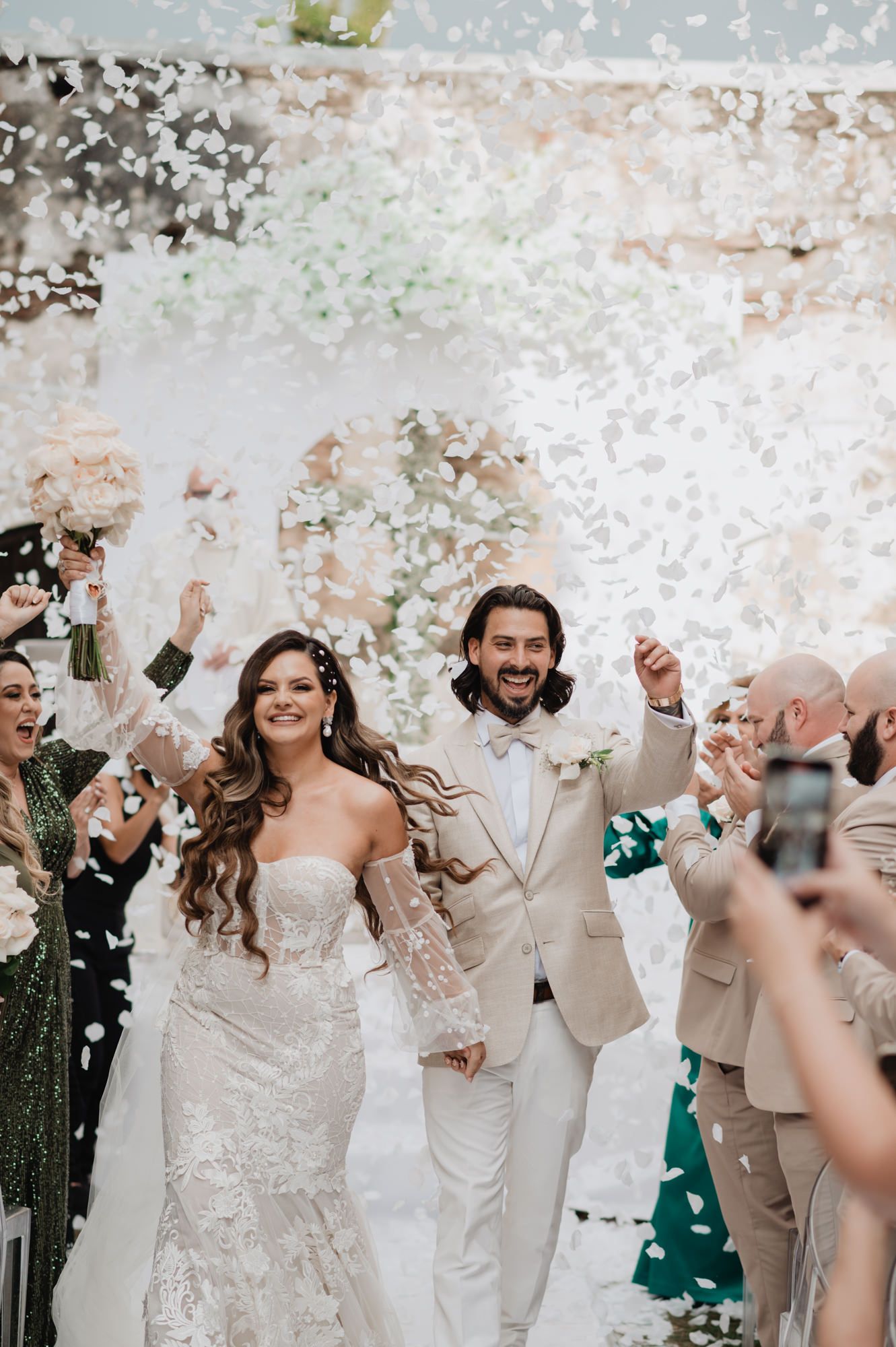 Wedding celebration with white confetti being thrown in the air during an outdoor celebration.