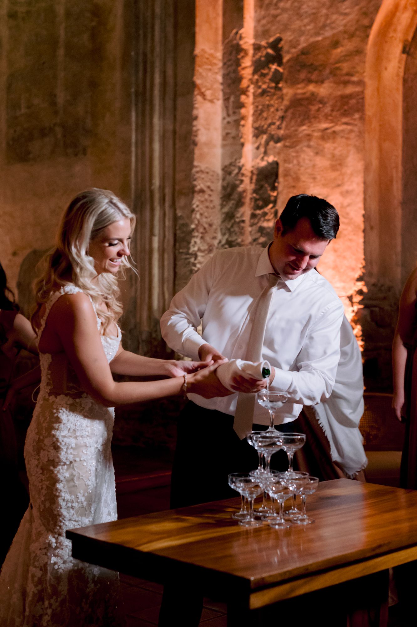 Couple performs champagne toast at rustic elegant wedding reception.