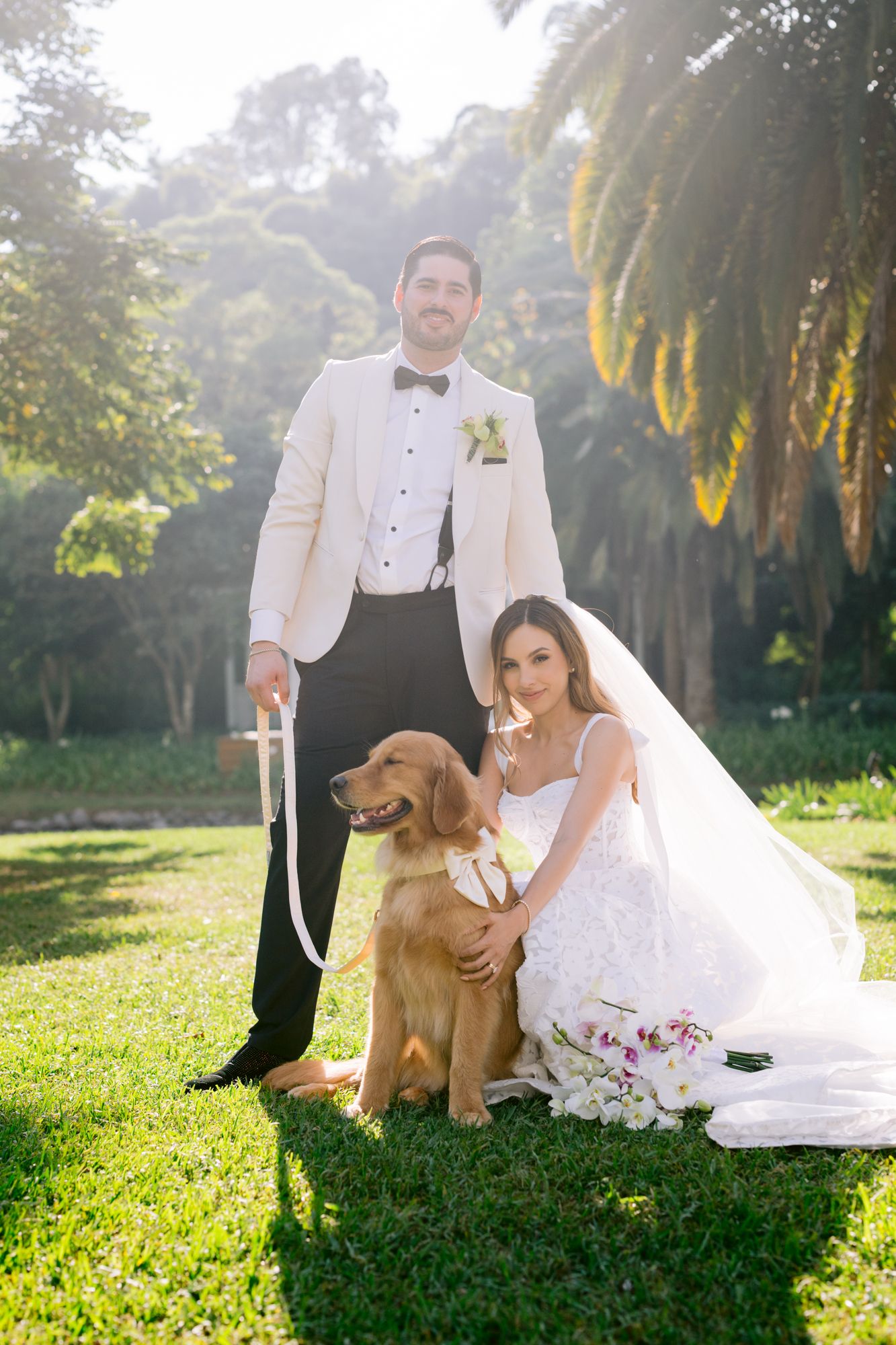 Wedding photos featuring a couple and their golden retriever in a sun-dappled garden setting.