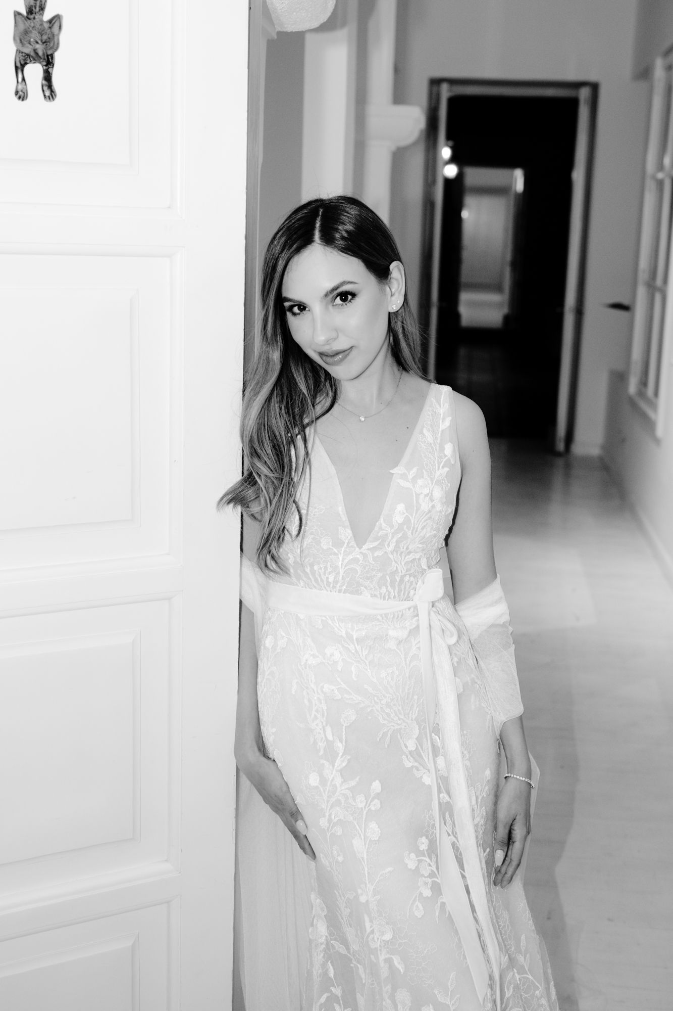 A series of artistic black and white portraits showing a person in a white dress against a minimalist interior background.