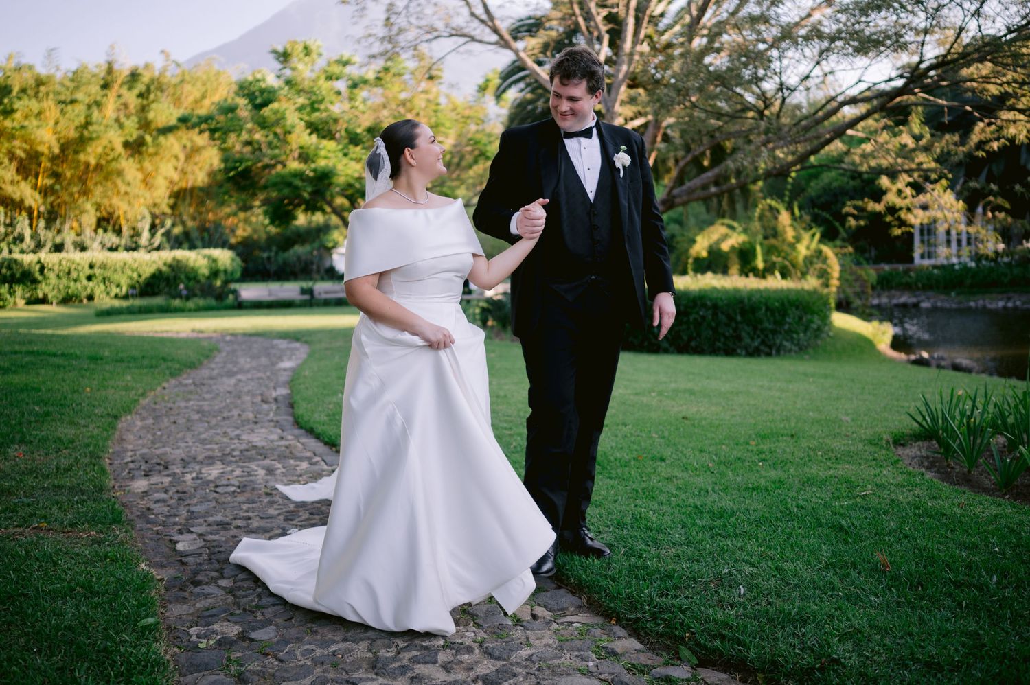 Wedding celebration in a garden setting with couple walking along a winding stone path.