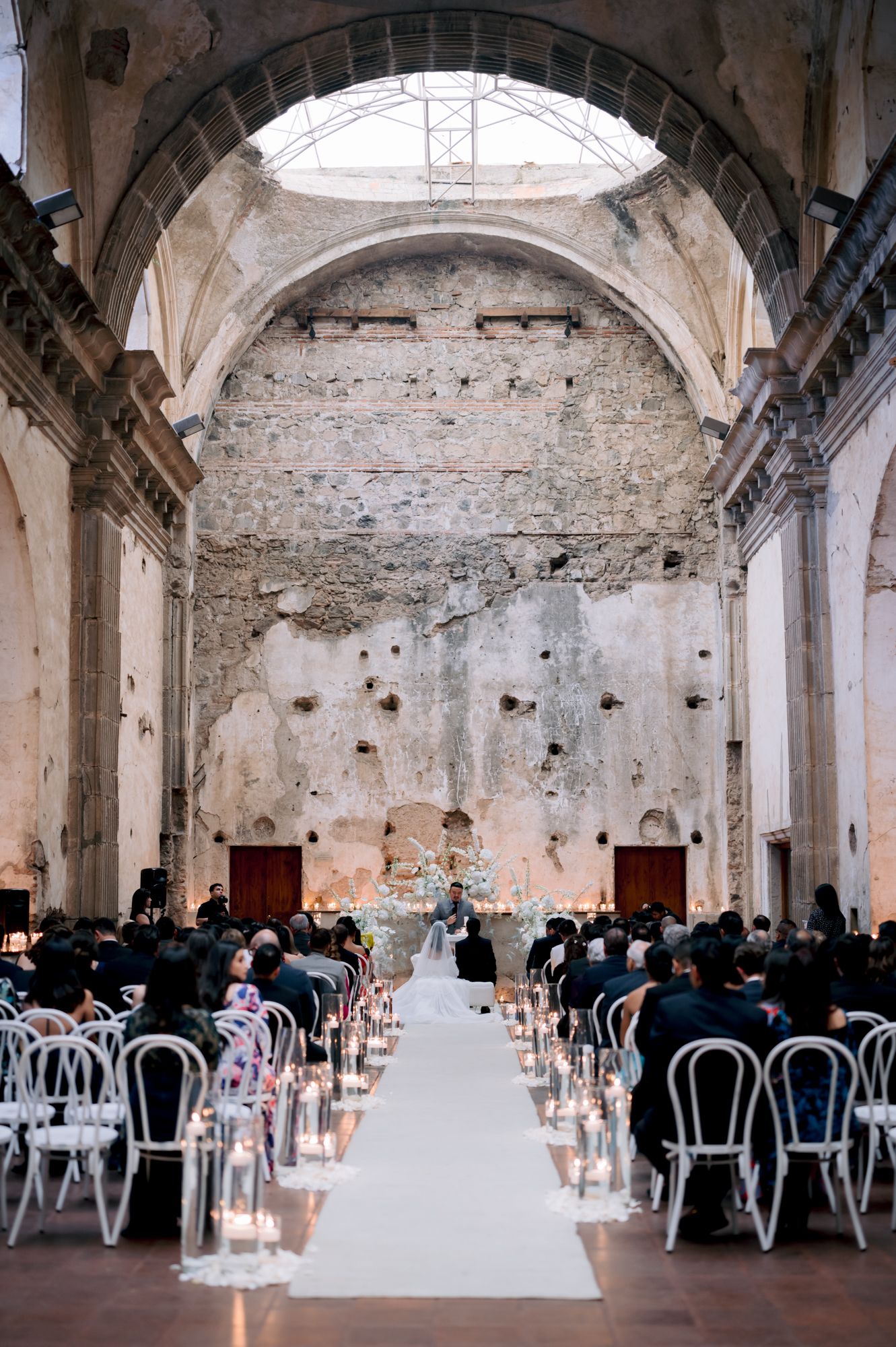 Historic church venue with vaulted ceilings and white chairs lined for wedding ceremony.
