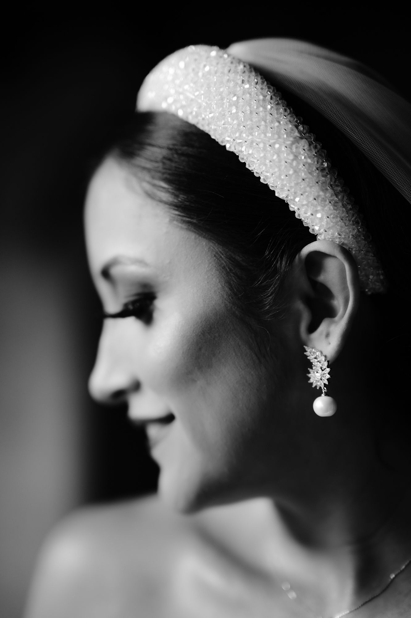 Black and white profile shot of bride wearing sparkly headband and pearl earring.