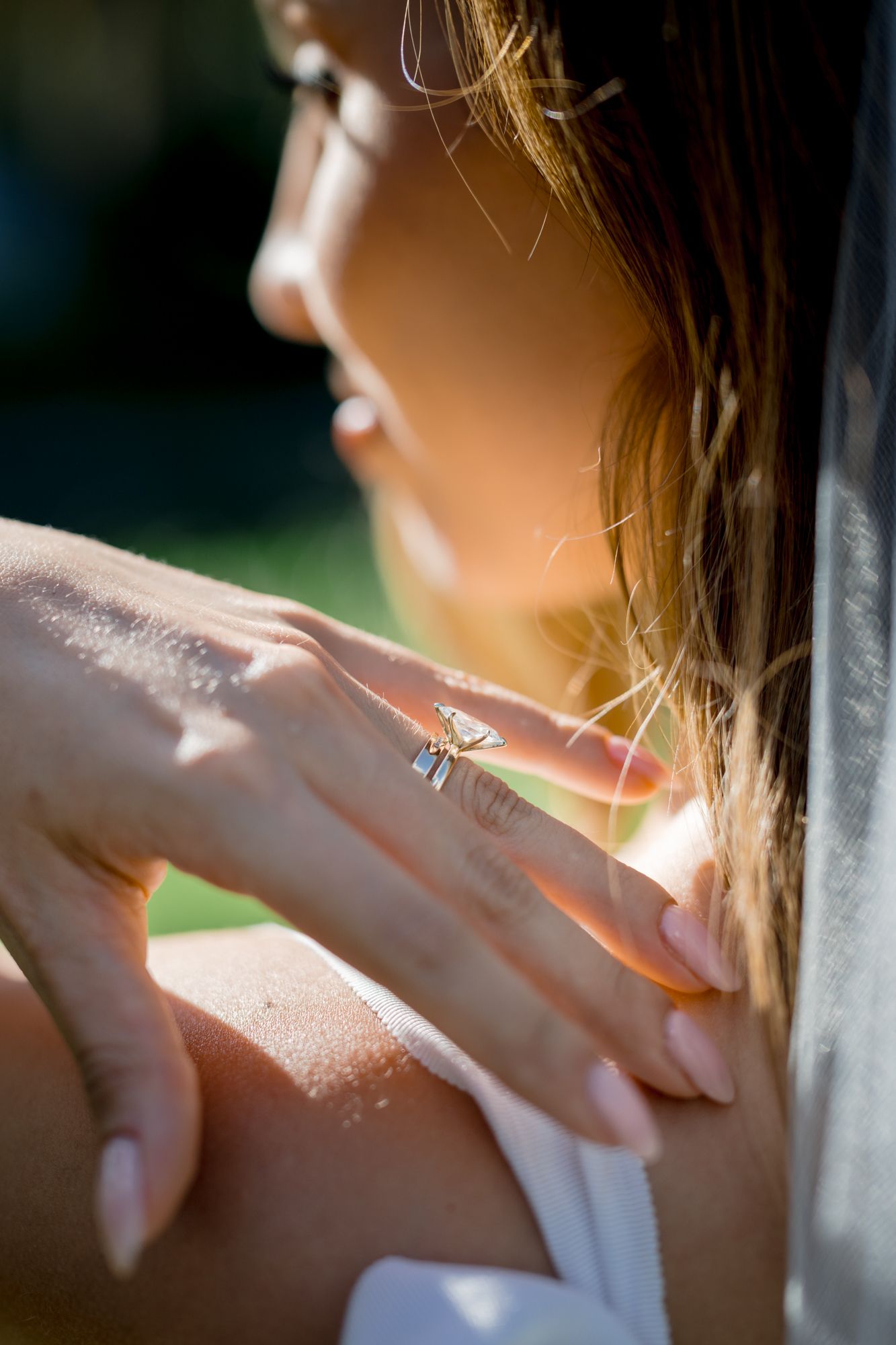 Sunlight illuminates a person's profile and shoulder through a window creating a warm, ethereal glow.