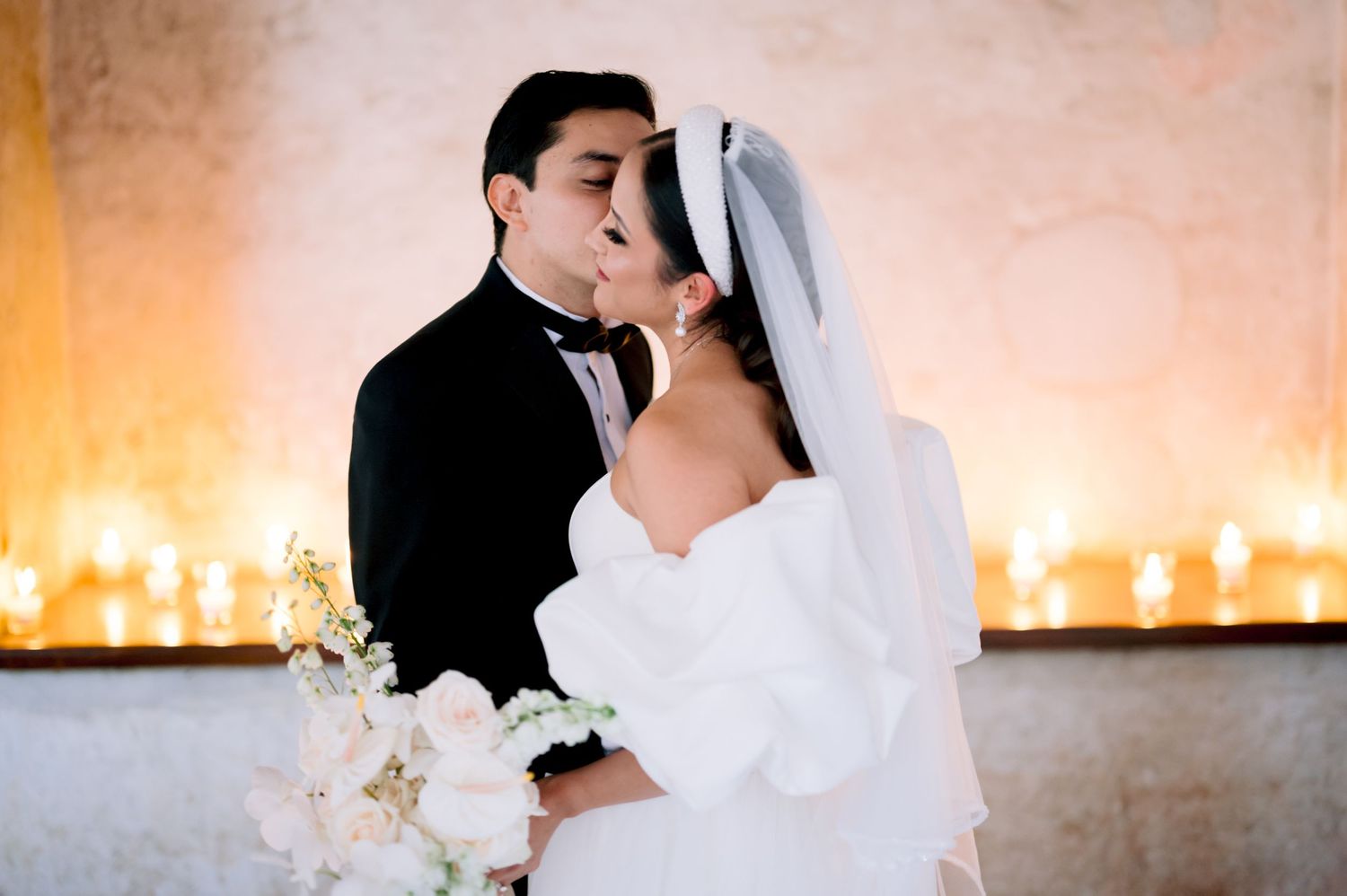Romantic wedding moment captured in warm lighting with white orchids.