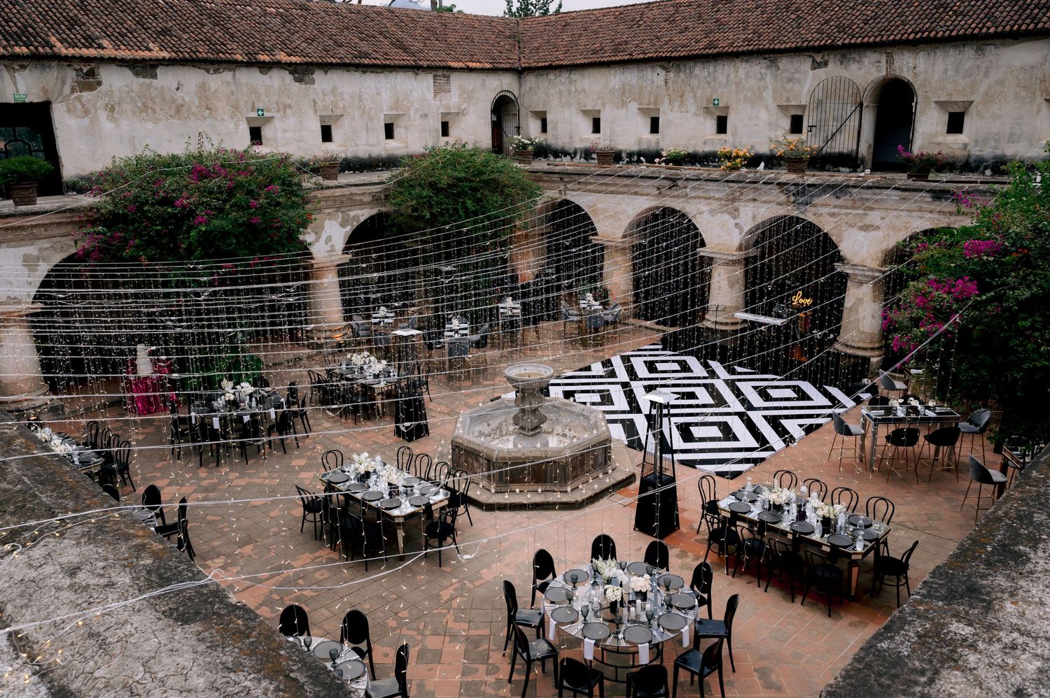 Overhead view of elegant courtyard wedding reception with geometric black and white dance floor.