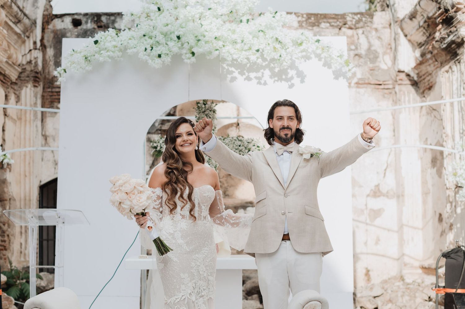 Romantic wedding photo collage showing elegant white floral arrangements and decor in a rustic venue.