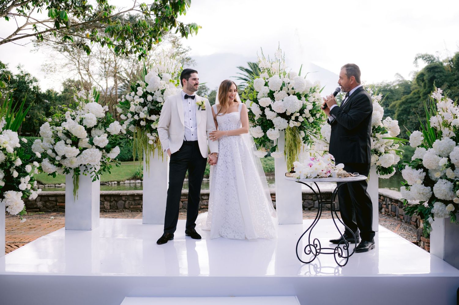 A series of elegant outdoor wedding ceremony photos featuring white floral arrangements and decorative elements.