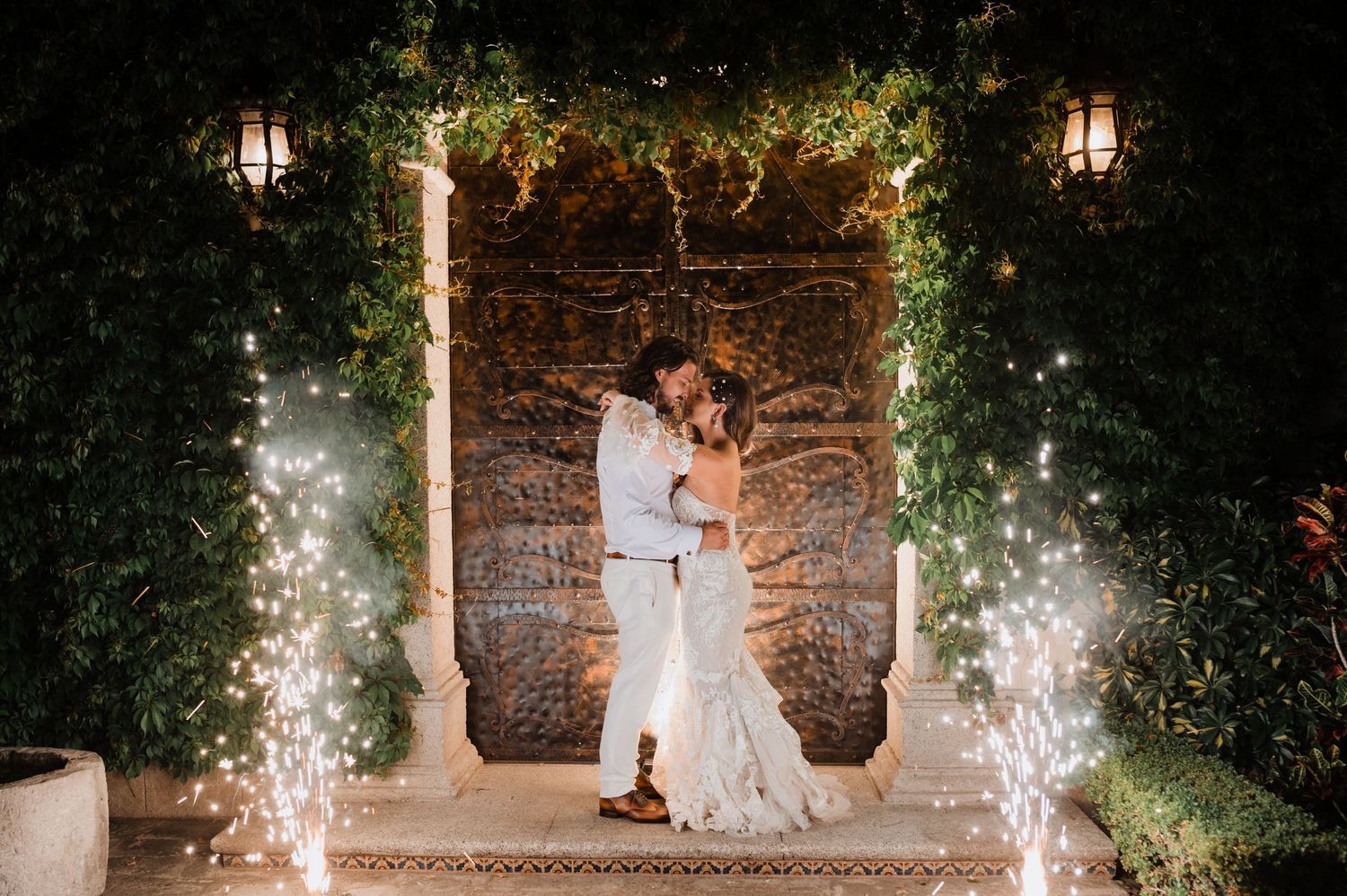 Evening wedding celebration with sparklers and string lights creating a magical atmosphere.
