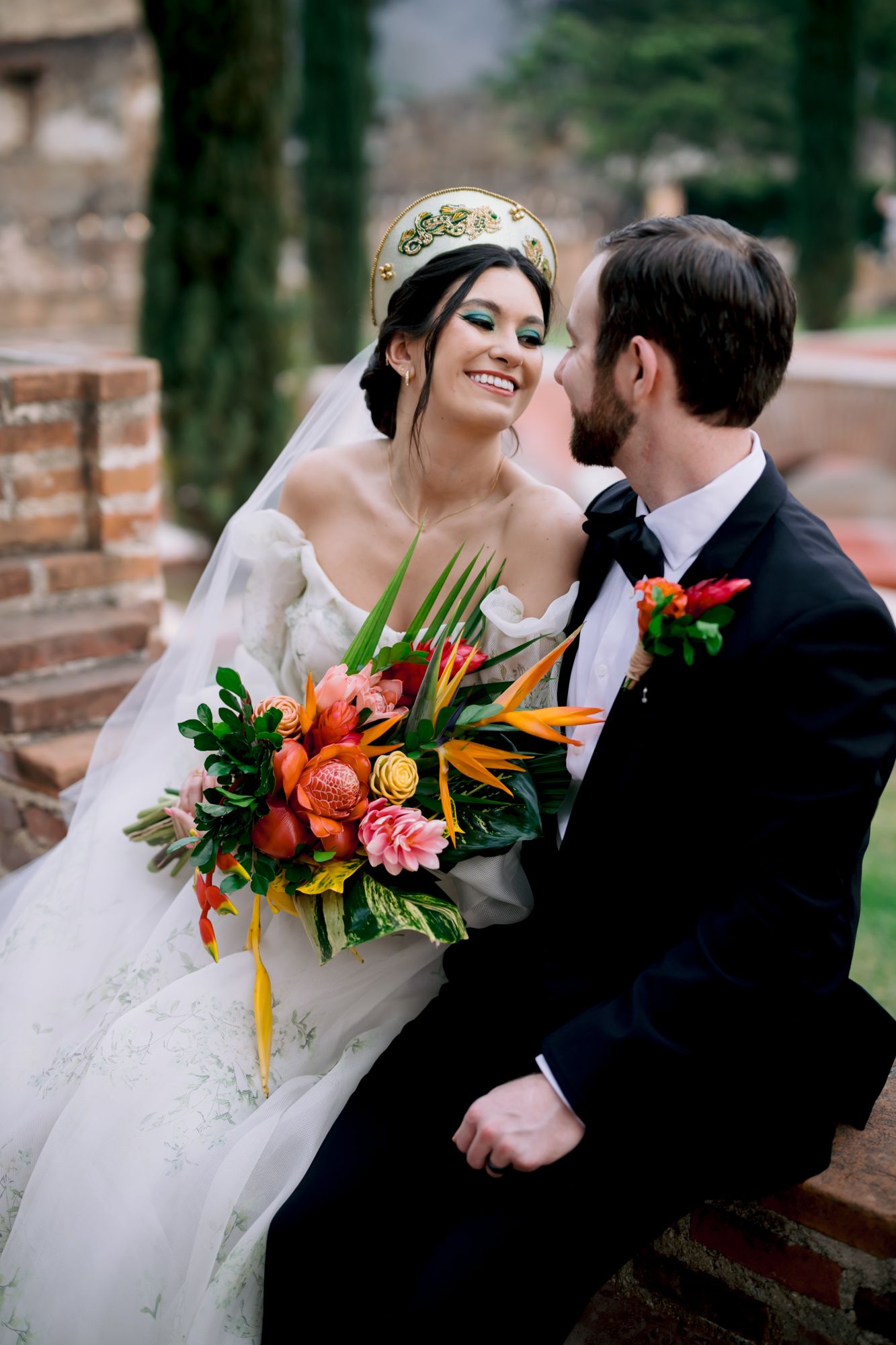 Romantic wedding moment with tropical bouquet featuring birds of paradise and orange florals.
