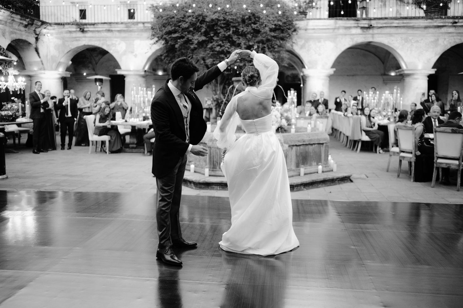 Dancing couple celebrating on an elegant ballroom floor during wedding reception.