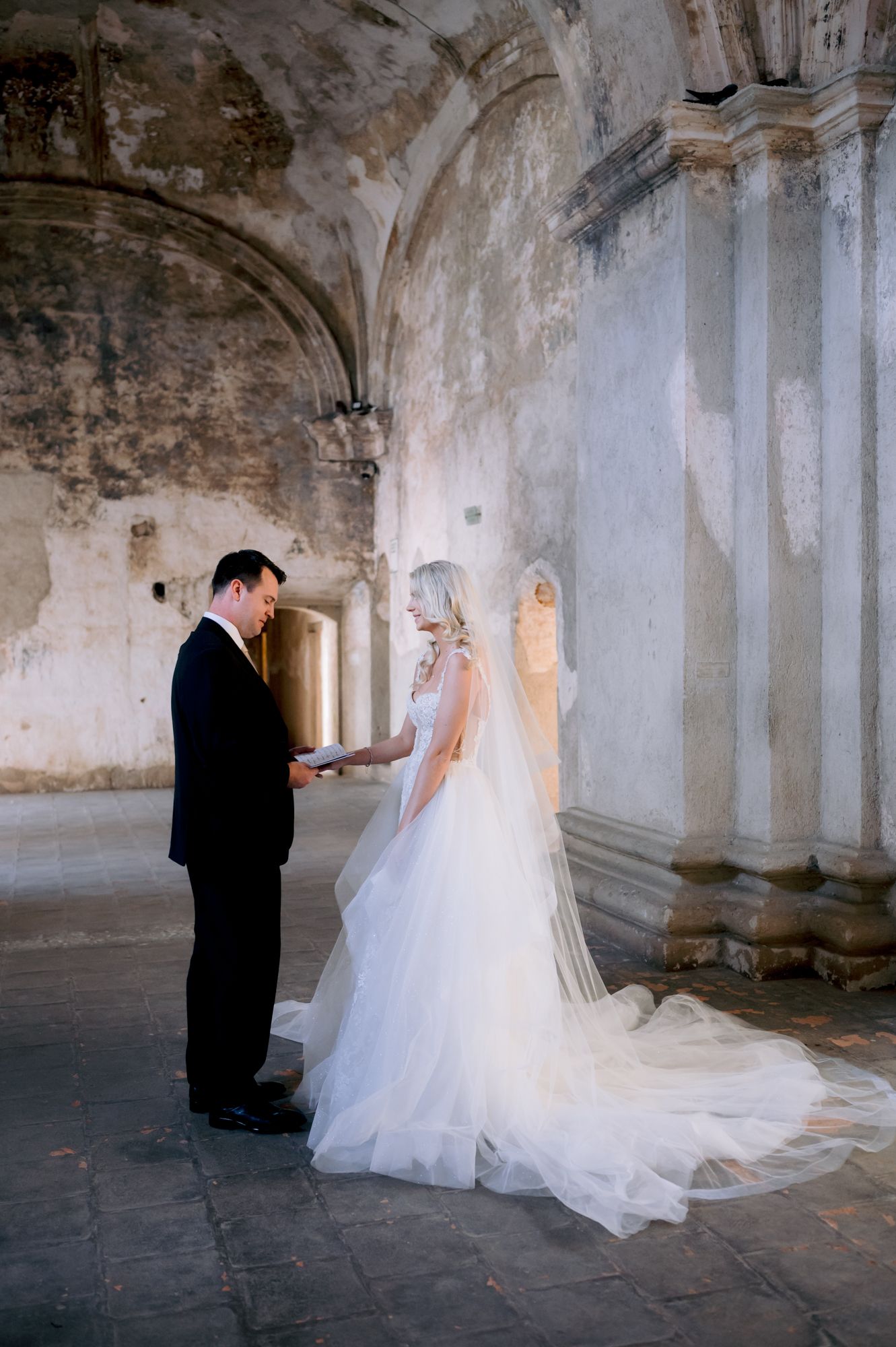 Wedding ceremony moment captured in historic stone building with elegant architectural details.