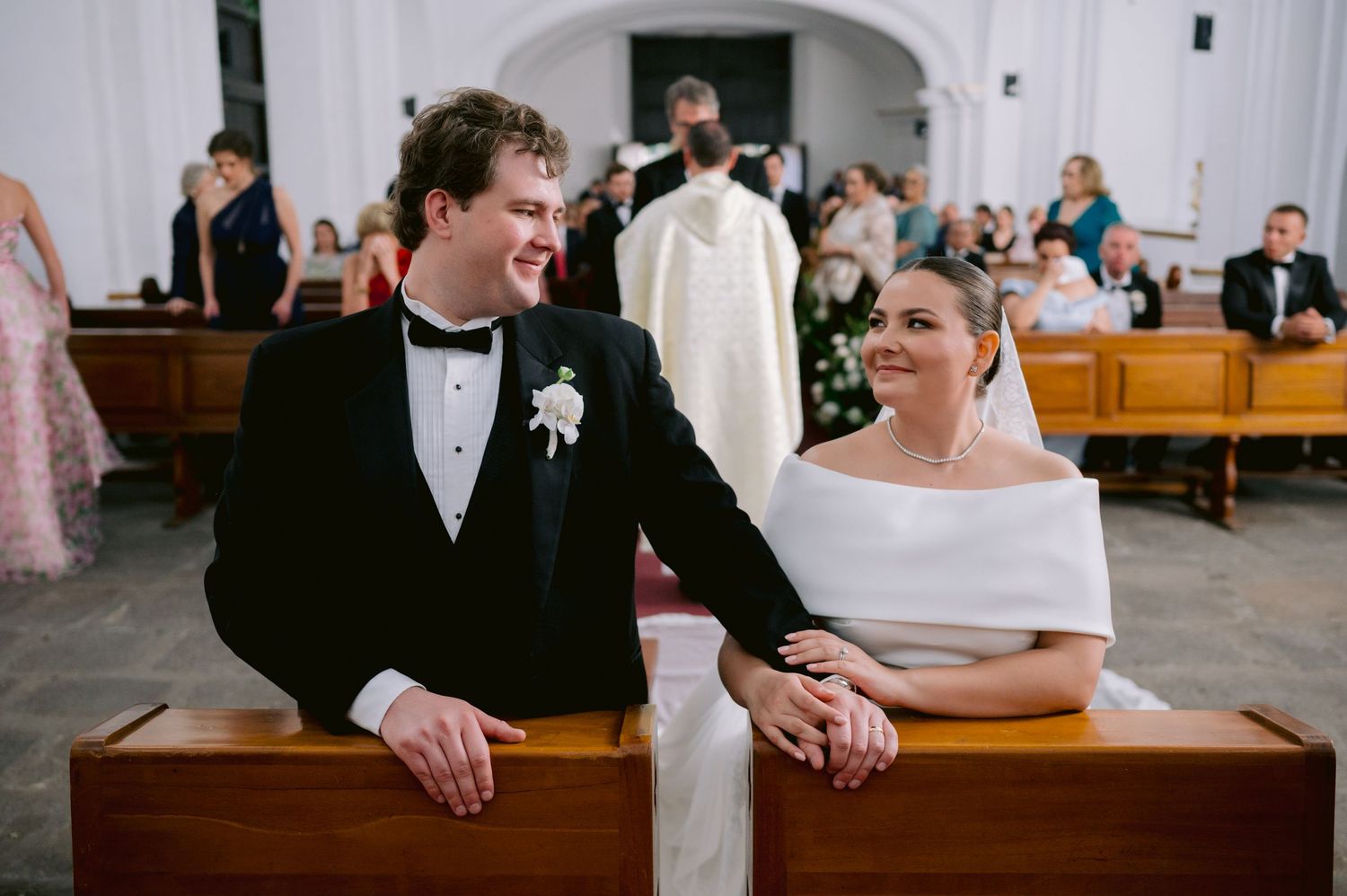 A joyful moment captured during a church wedding ceremony as the couple sits together.