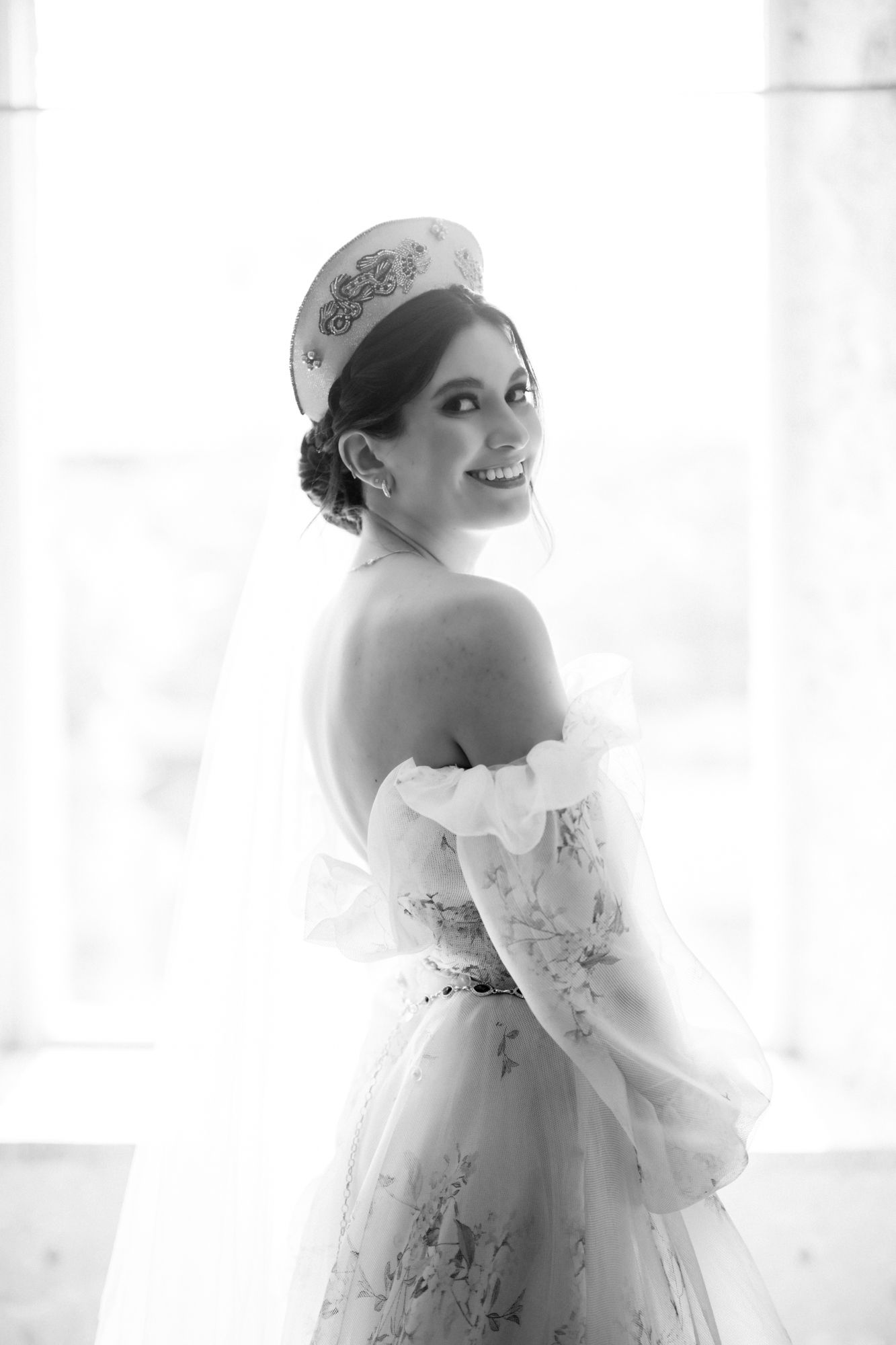 Classic black and white bridal portrait with vintage-inspired headpiece and off-shoulder gown.