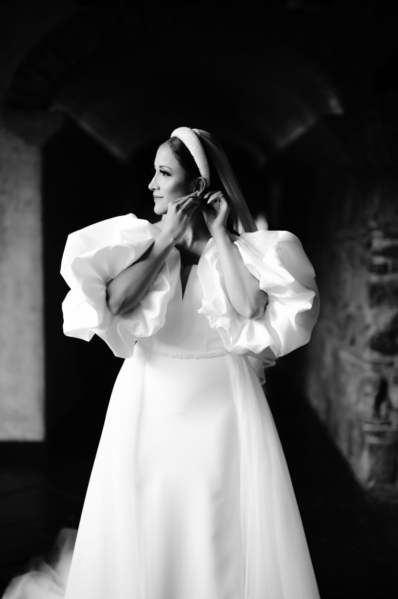 Black and white photo of bride in dramatic puff sleeve wedding dress.