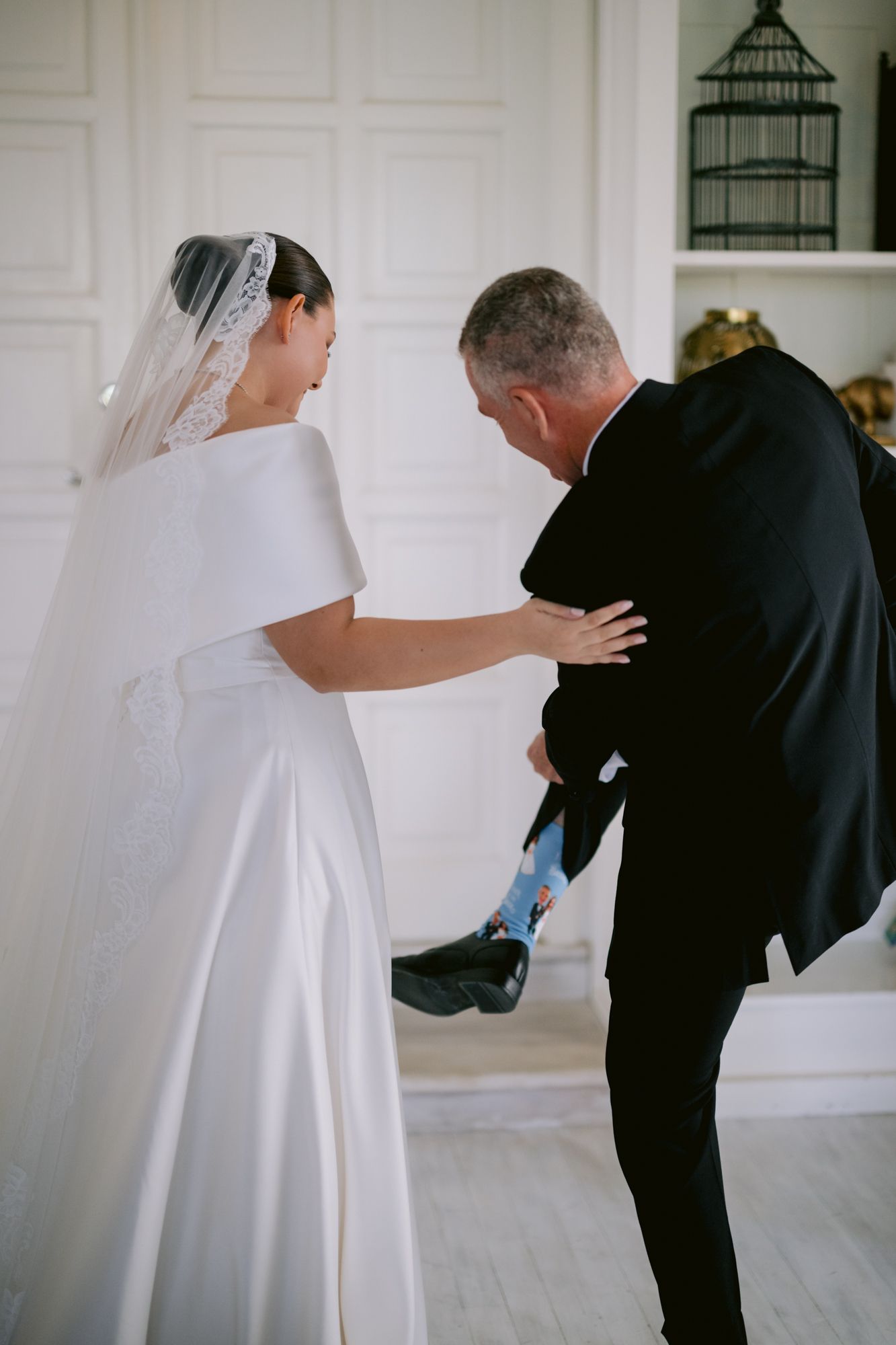 A candid moment during wedding preparations showing playful interaction in a bright white room.